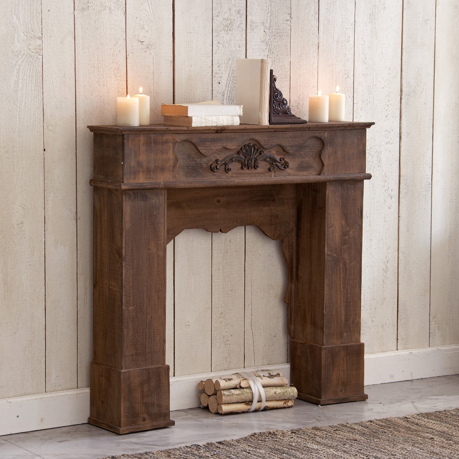 Consola de chimenea Margaux Chimenea decorativa de madera oscura con diseño tallado, adornada con velas y libros