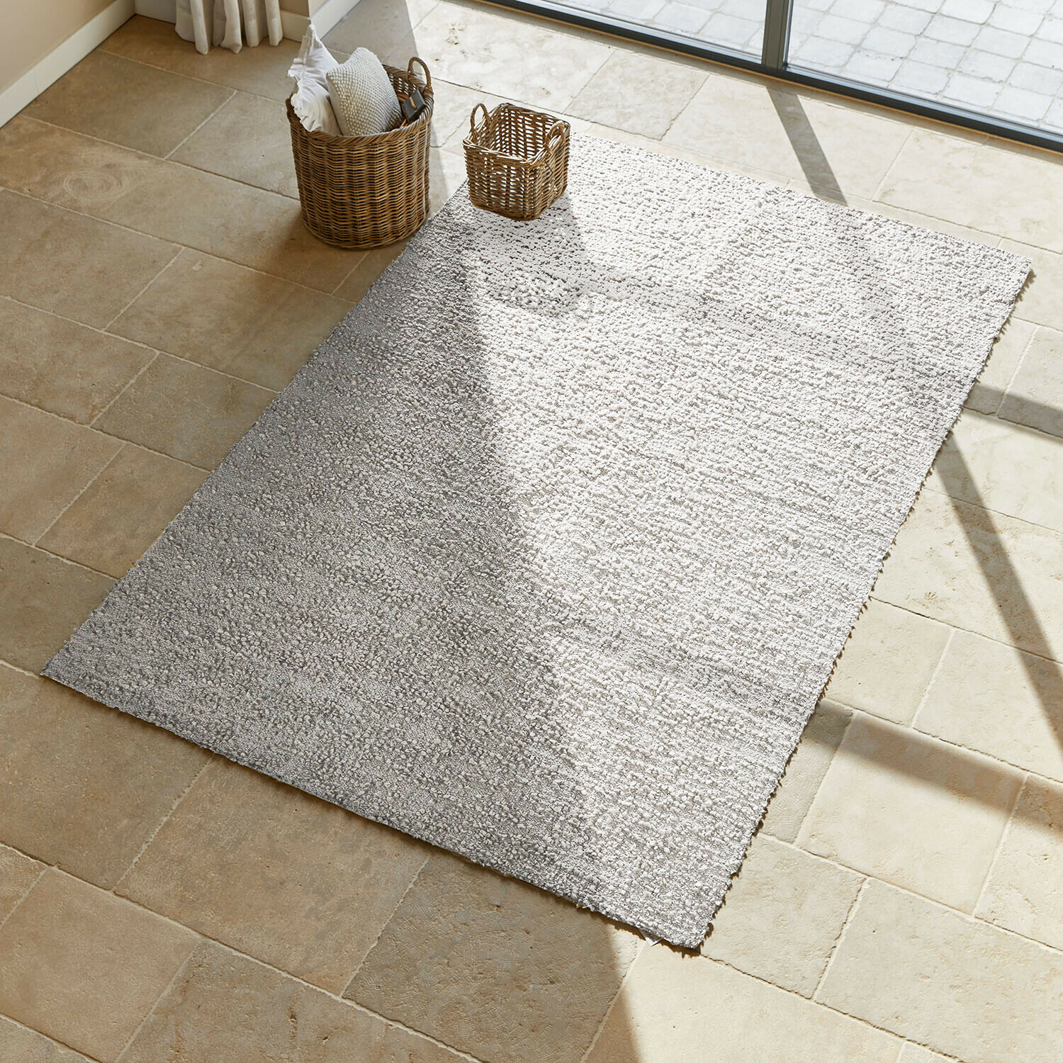 Alfombra Wodaha Alfombra gris claro de material suave sobre suelo beige que aporta calidez al ambiente