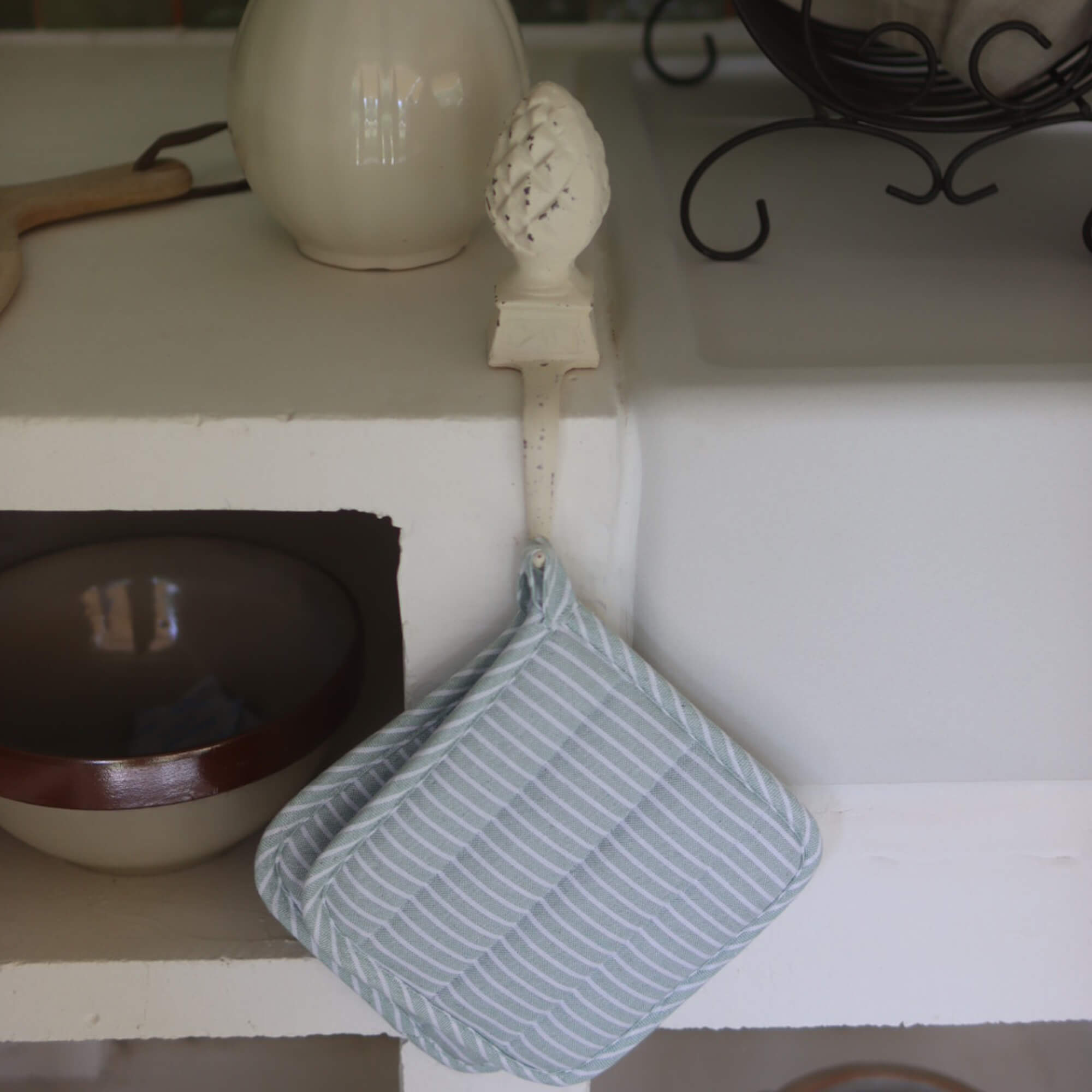 Manopla de cocina de algodón a rayas verde menta y blanco colgada en gancho metálico en cocina