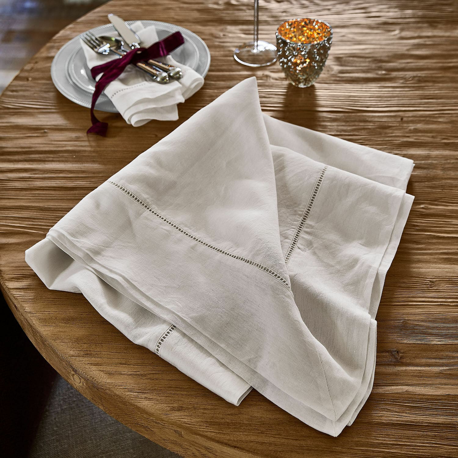 Mantel Covent Garden Mantel de lino blanco con bordado delicado sobre mesa de madera, decoración de mesa