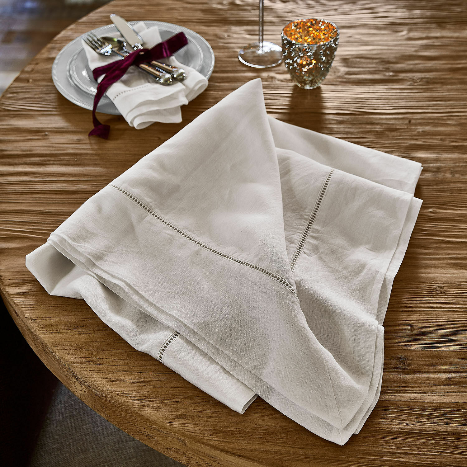 Mantel Covent Garden Mantel de lino blanco con bordado delicado sobre mesa de madera, decoración de mesa