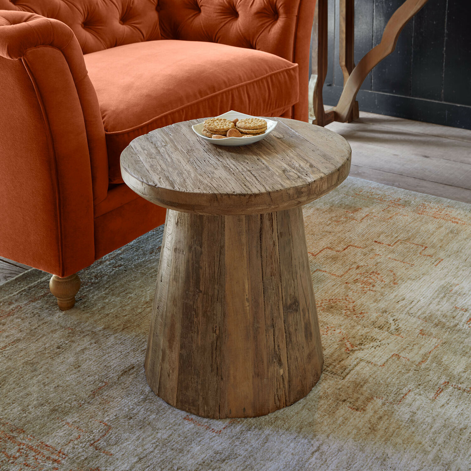 Mesa auxiliar Yarwood Mesa auxiliar de madera natural junto a un sofá naranja y alfombra con diseño sutil