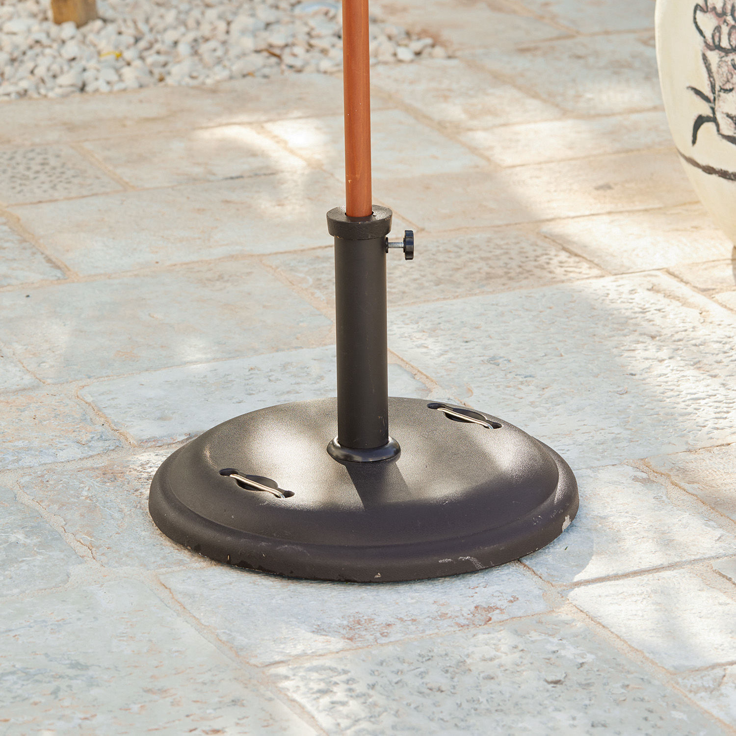 Soporte para sombrilla Yarra Base de parasol de metal negro sobre suelo de piedra para jardín o terraza