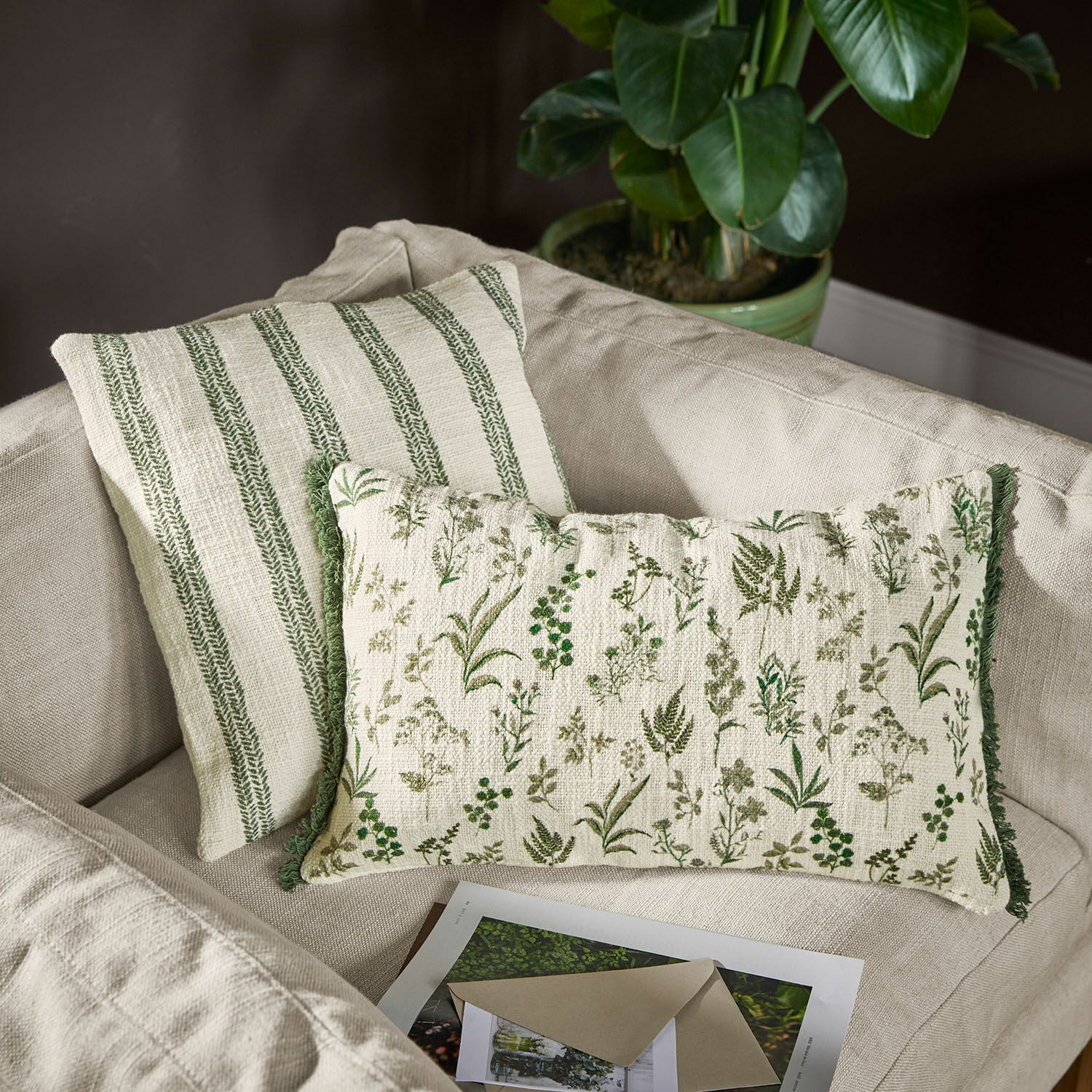Set de 2 fundas de cojín Wescombe Cojines decorativos reversibles de algodón con motivos vegetales verdes y rayas en sofá beige