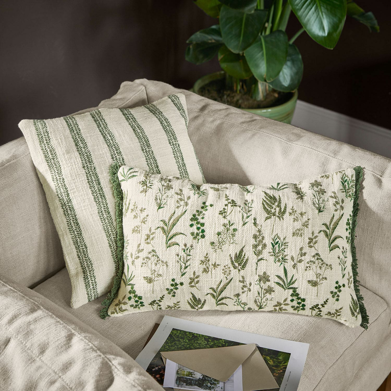 Set de 2 fundas de cojín Wescombe Cojines decorativos reversibles de algodón con motivos vegetales verdes y rayas en sofá beige
