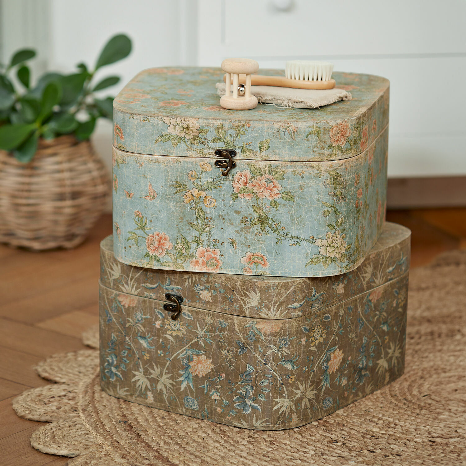 Set de 2 cajas Mafleur Dos cajas decorativas con diseño floral en colores pastel sobre alfombra de yute trenzado