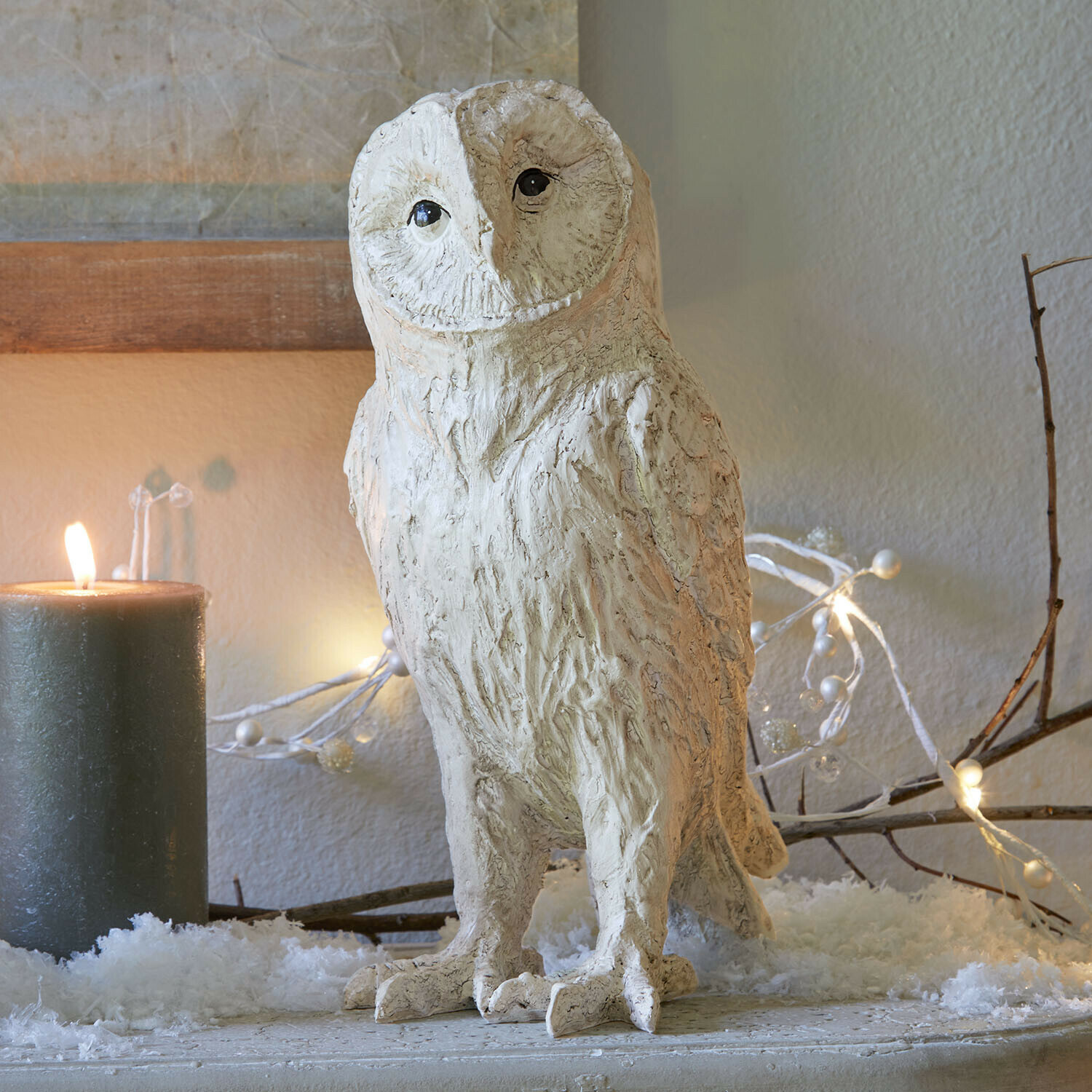 Búho decorativo Heriette Figura decorativa de búho en material claro sobre mesa festiva con vela y luces decorativas