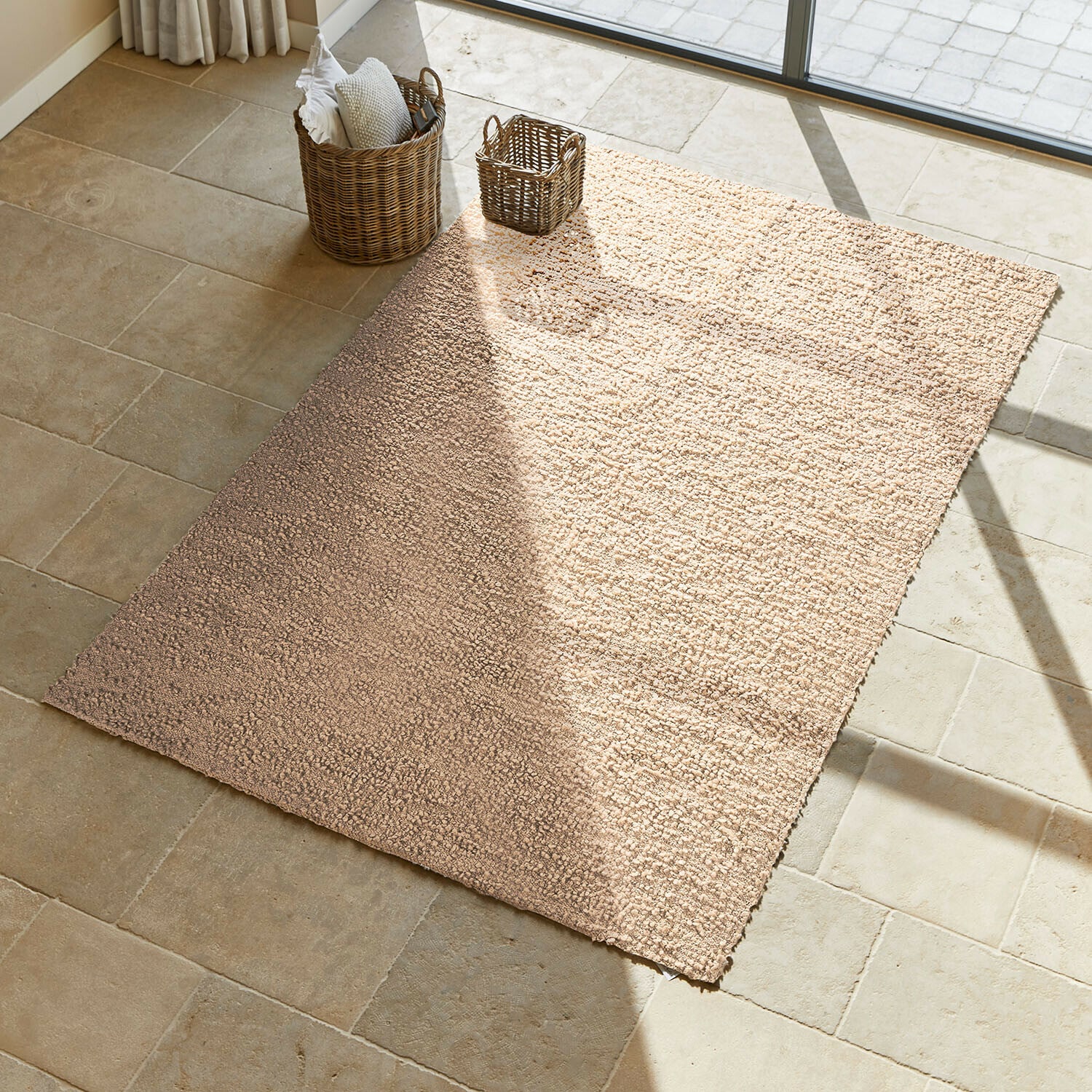 Alfombra Wodaha Alfombra beige de material suave sobre suelo de piedra clara en habitación soleada