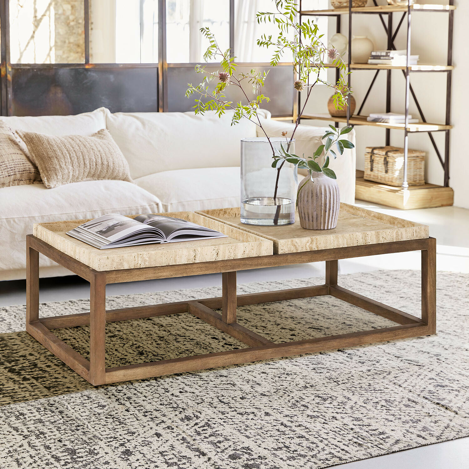 Mesa de centro Edwyn Mesa de centro de madera clara con superficie de piedra beige en salón moderno y luminoso