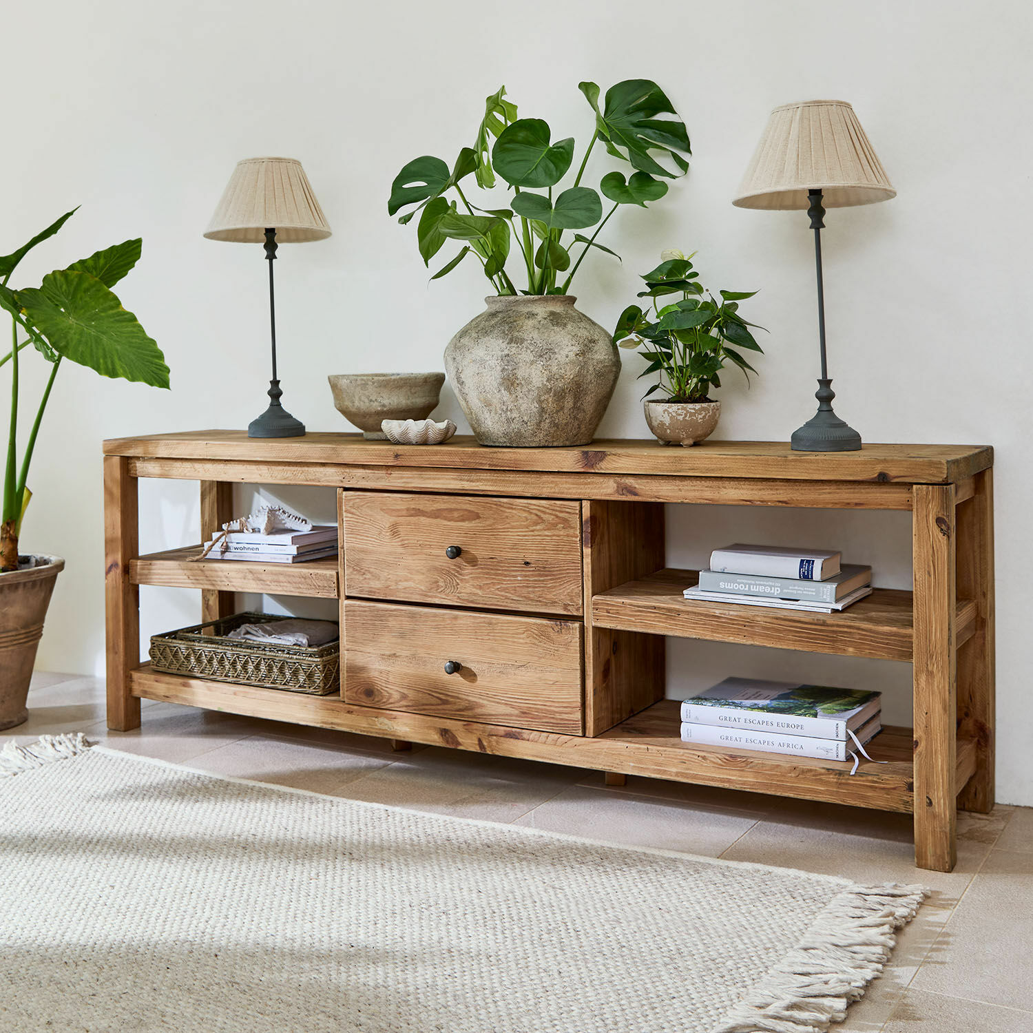 Aparador Ainvelle Consola de madera natural con cajones y estantes, decorada con plantas y lámparas beige
