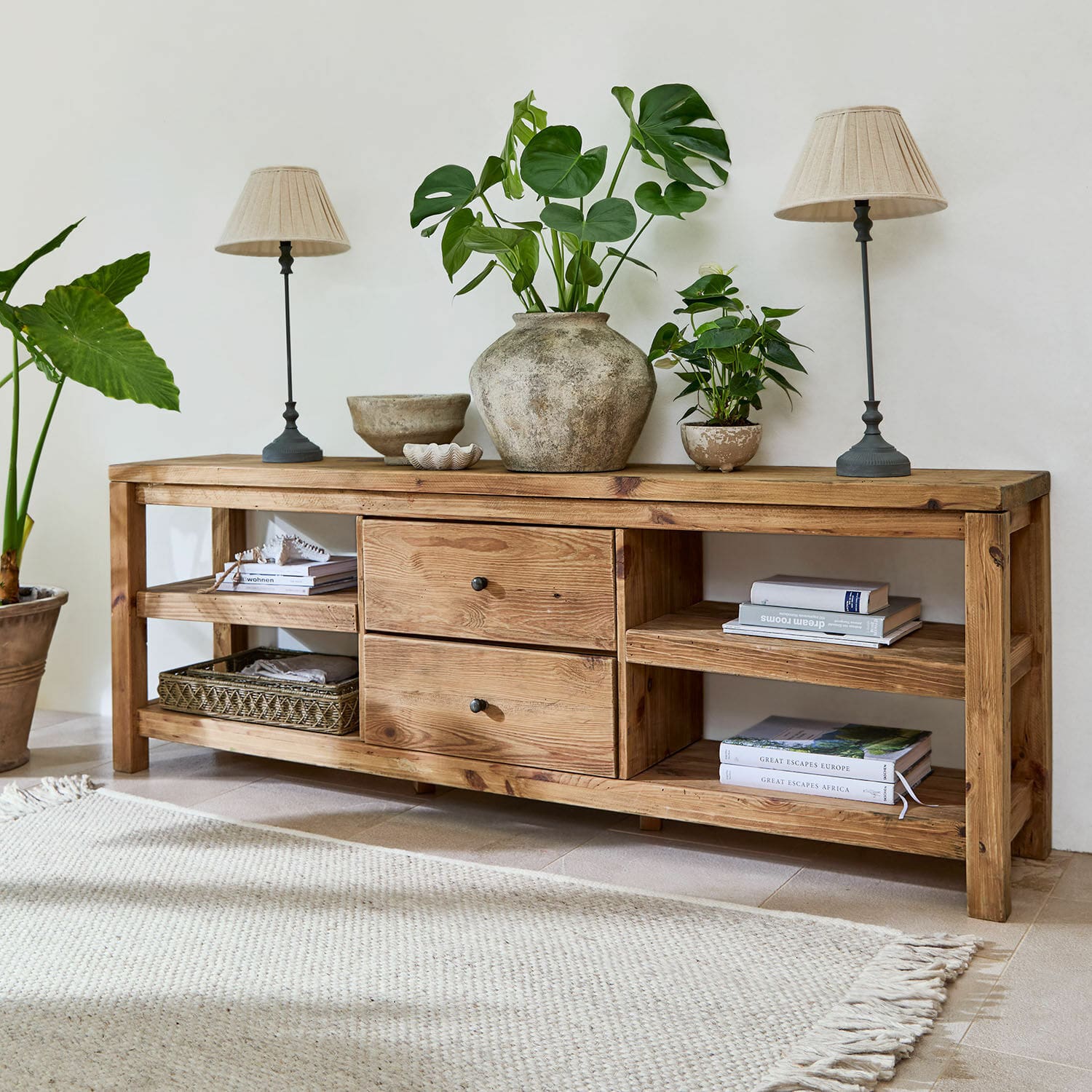 Aparador Ainvelle Consola de madera natural con cajones y estantes, decorada con plantas y lámparas beige