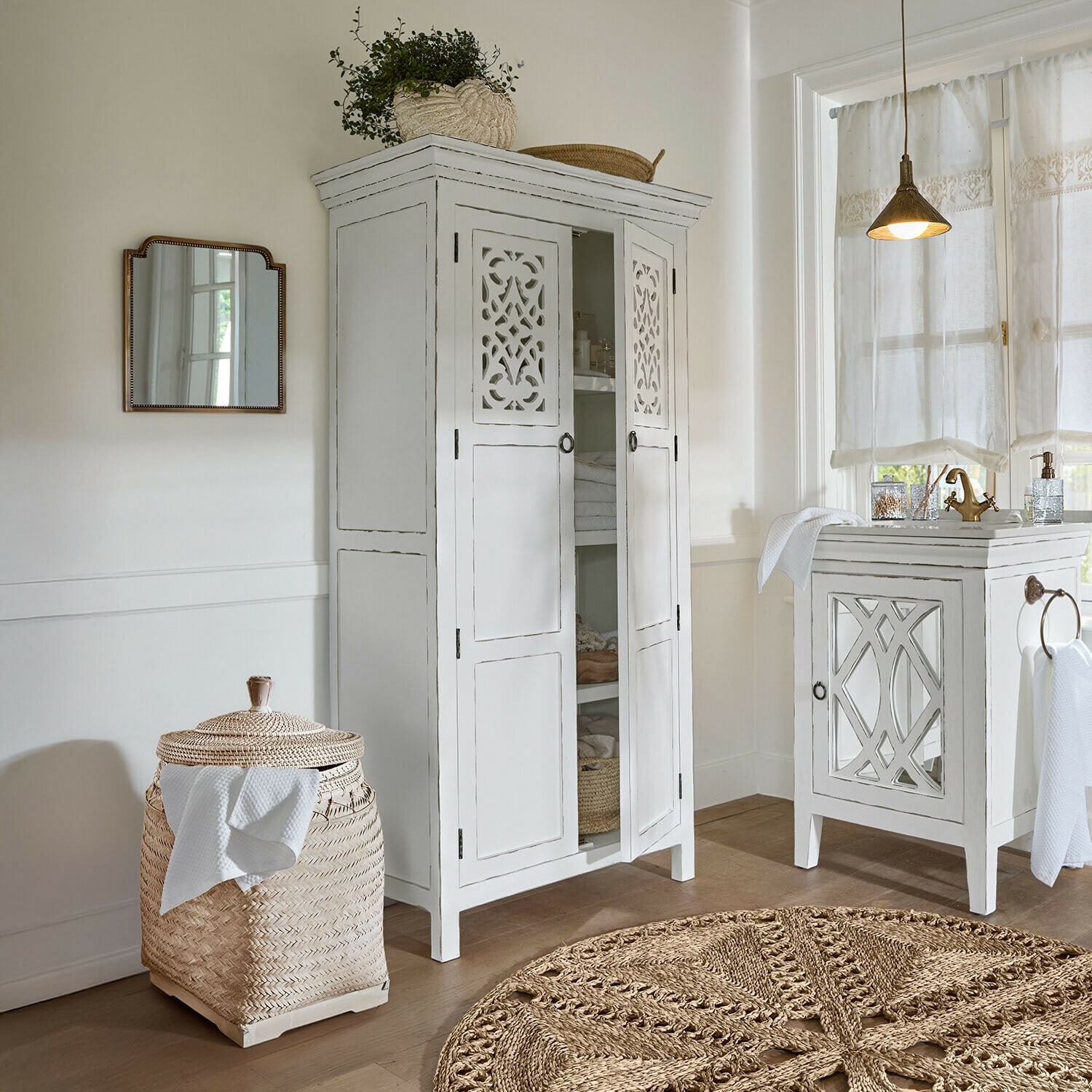 Armario Marvoux Armario blanco de madera con puertas caladas y cesta de ratán trenzado en baño luminoso