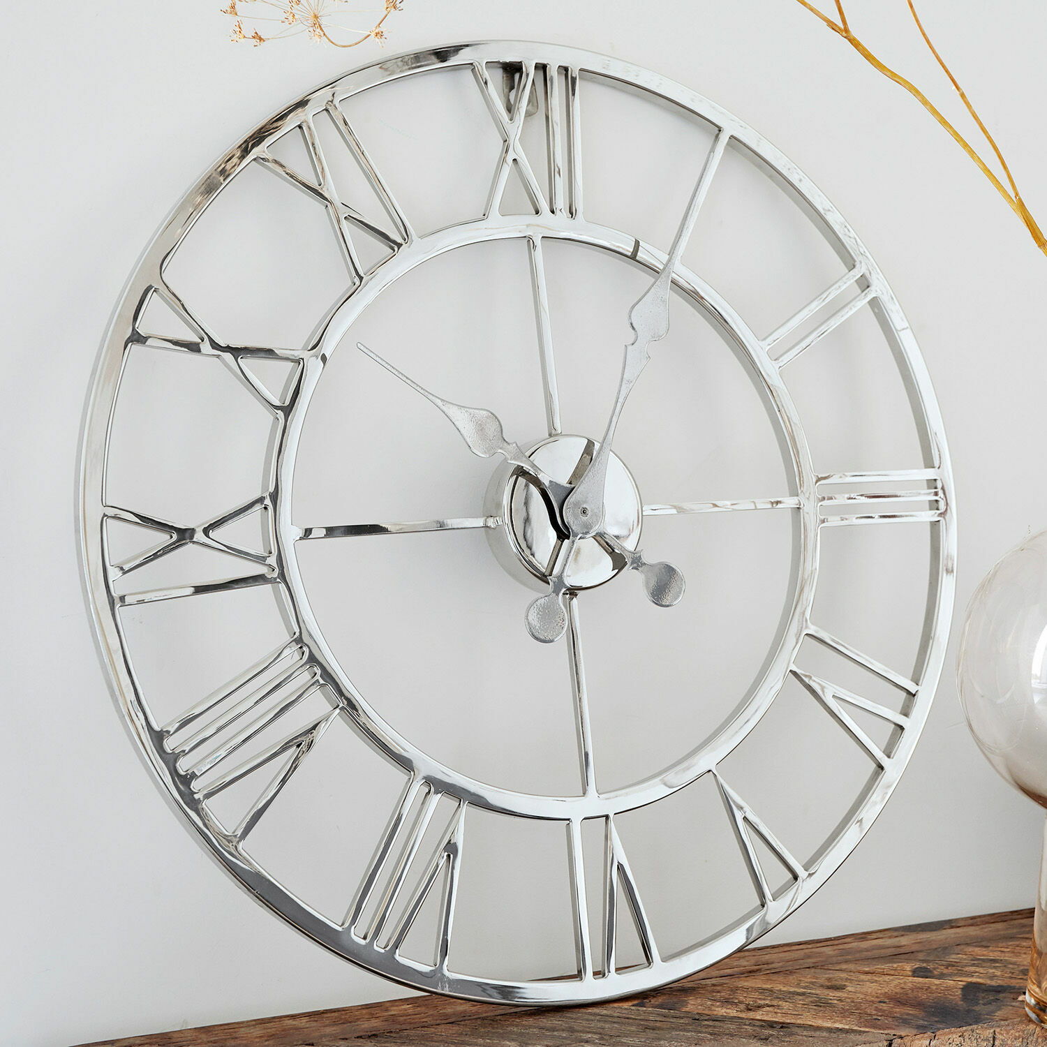 Reloj Houston Reloj de pared redondo de metal plateado con números romanos sobre mesa de madera