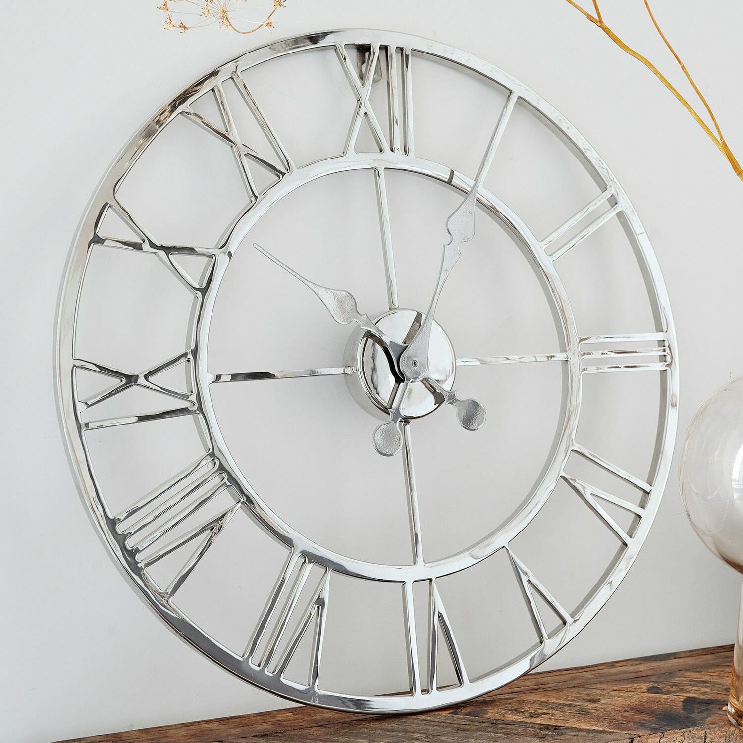 Reloj Houston Reloj de pared redondo de metal plateado con números romanos sobre mesa de madera