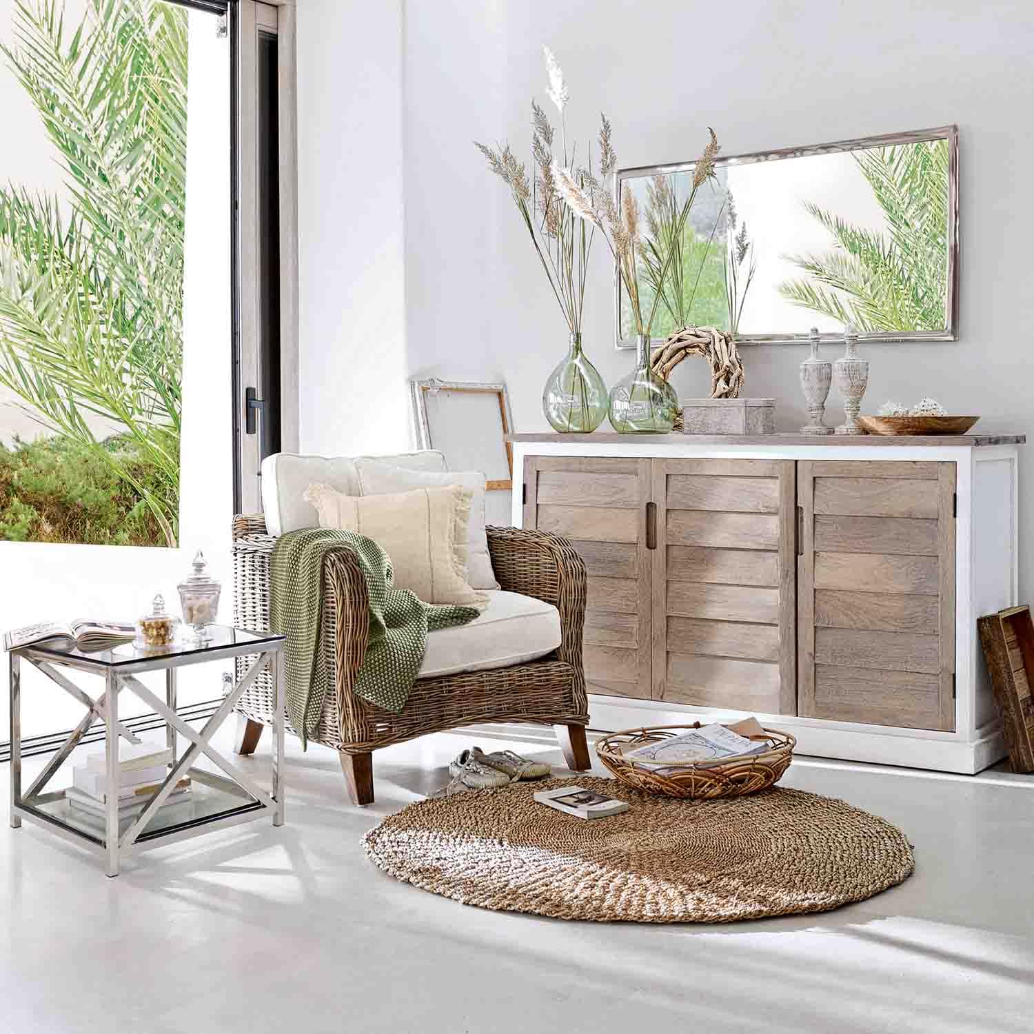 Salón acogedor con sillón de mimbre, aparador de madera clara y alfombra redonda natural en tonos suaves