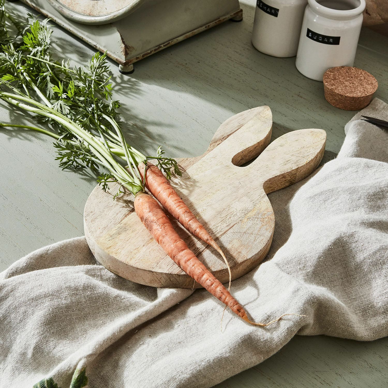 Tabla de cortar Nante Tabla de cortar de madera con forma de conejo y dos zanahorias frescas sobre tela de lino
