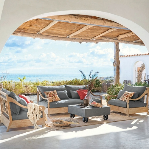 Conjunto de muebles de jardín de madera con cojines grises en terraza con vista al mar, mobiliario de exterior