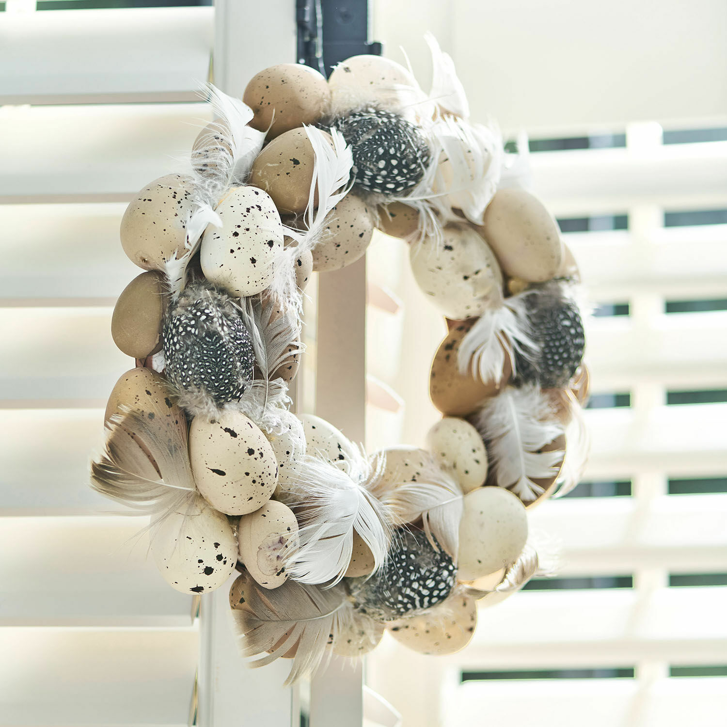 Corona con huevos Harera Corona decorativa con plumas beige y negras y huevos artificiales para decoración primaveral