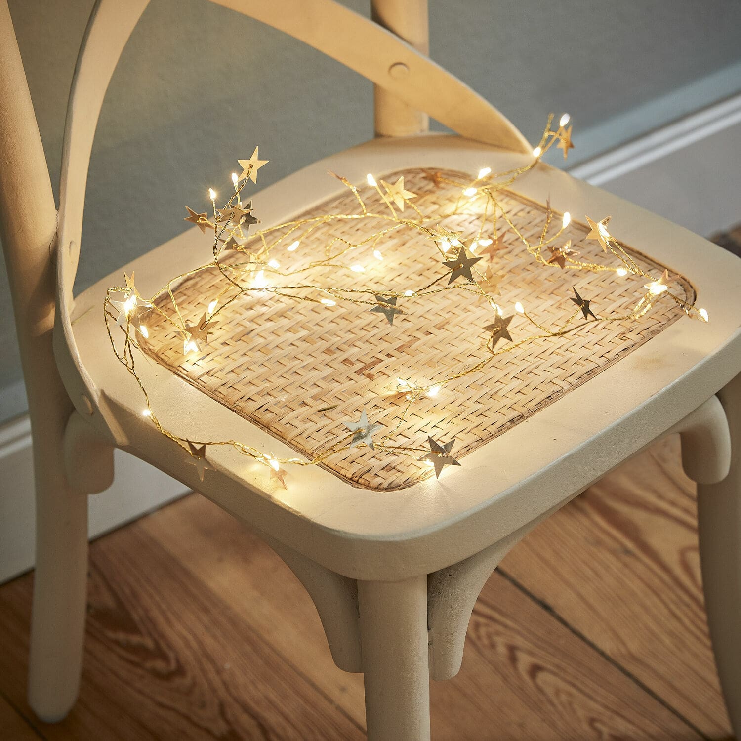 Cadena de luces Vernham Cadena de luces con estrellas en luz cálida sobre asiento de mimbre claro