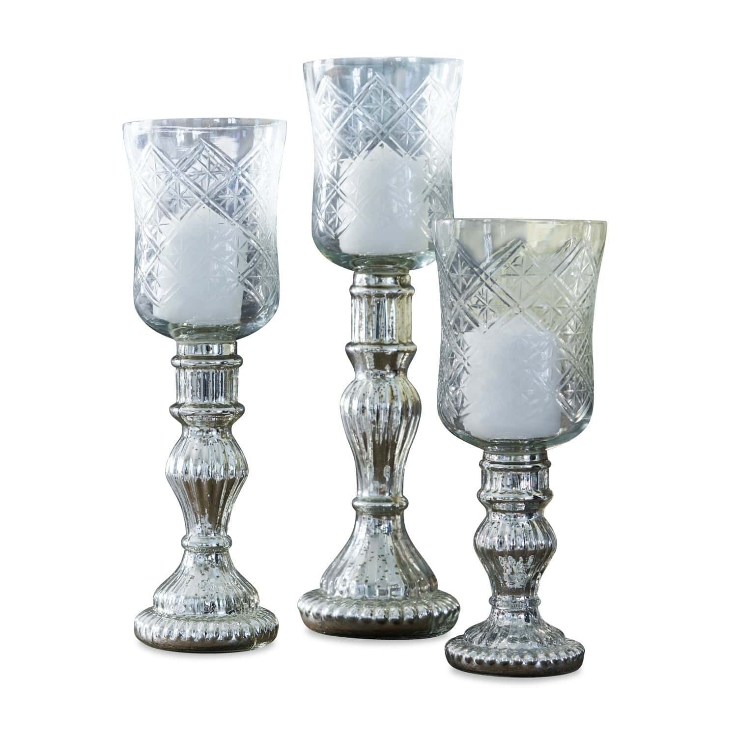Conjunto de tres candelabros de vidrio con velas blancas y base decorativa plateada