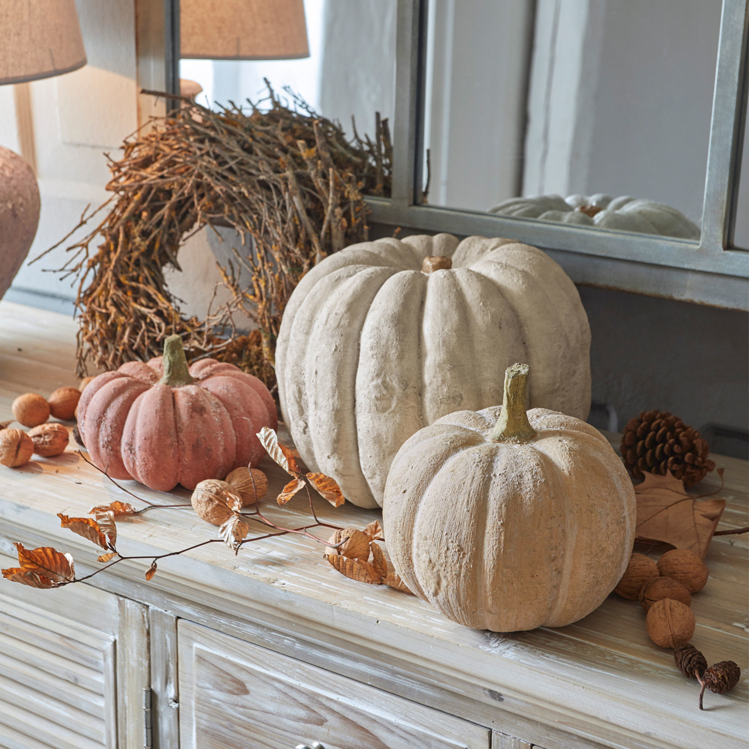 Set de 3 calabazas Pumpkin Calabazas decorativas de hormigón beige y rosa sobre cómoda de madera con accesorios otoñales