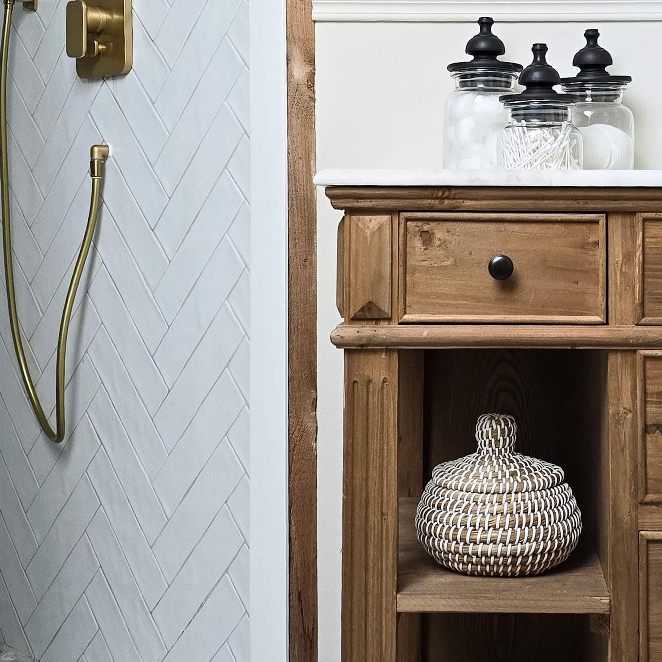 Mueble de baño rústico de madera con encimera blanca y frascos de vidrio para accesorios