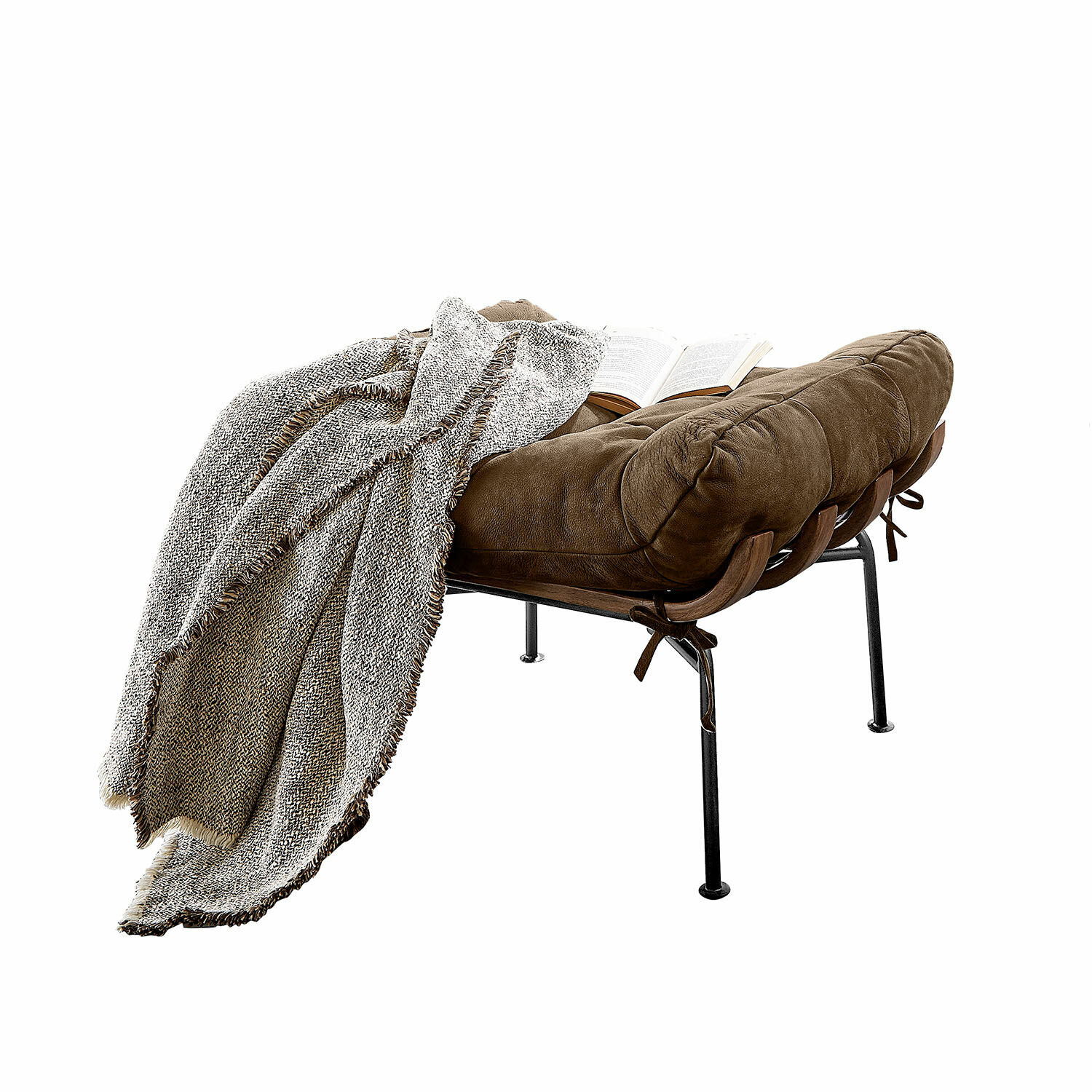 Taburete Horraine Sillón de cuero marrón con patas de metal, manta gris y libro abierto sobre el asiento