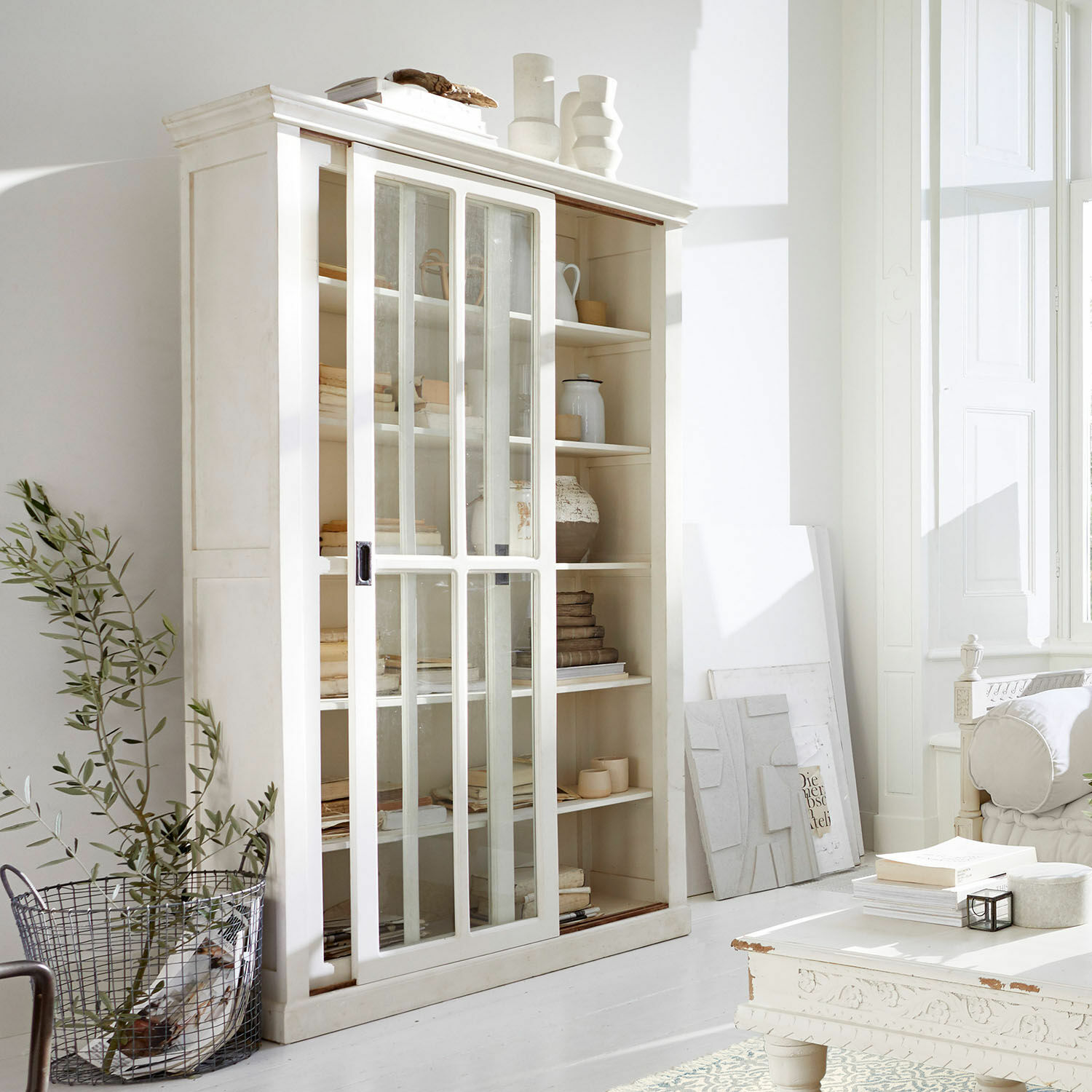 Armario Brouns Vitrina blanca de madera con puertas correderas de vidrio en sala moderna y luminosa