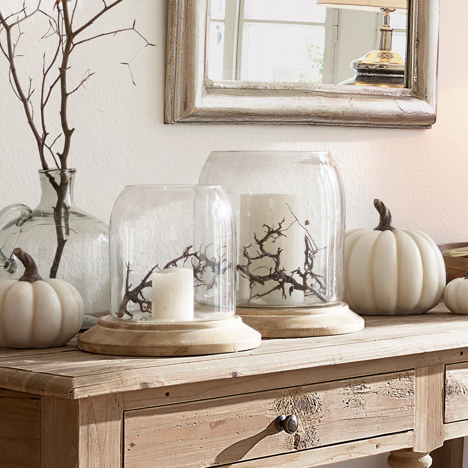 Set de 2 farolillos Bran Campanas de cristal decorativas con base de madera, velas blancas y ramas sobre mesa de madera