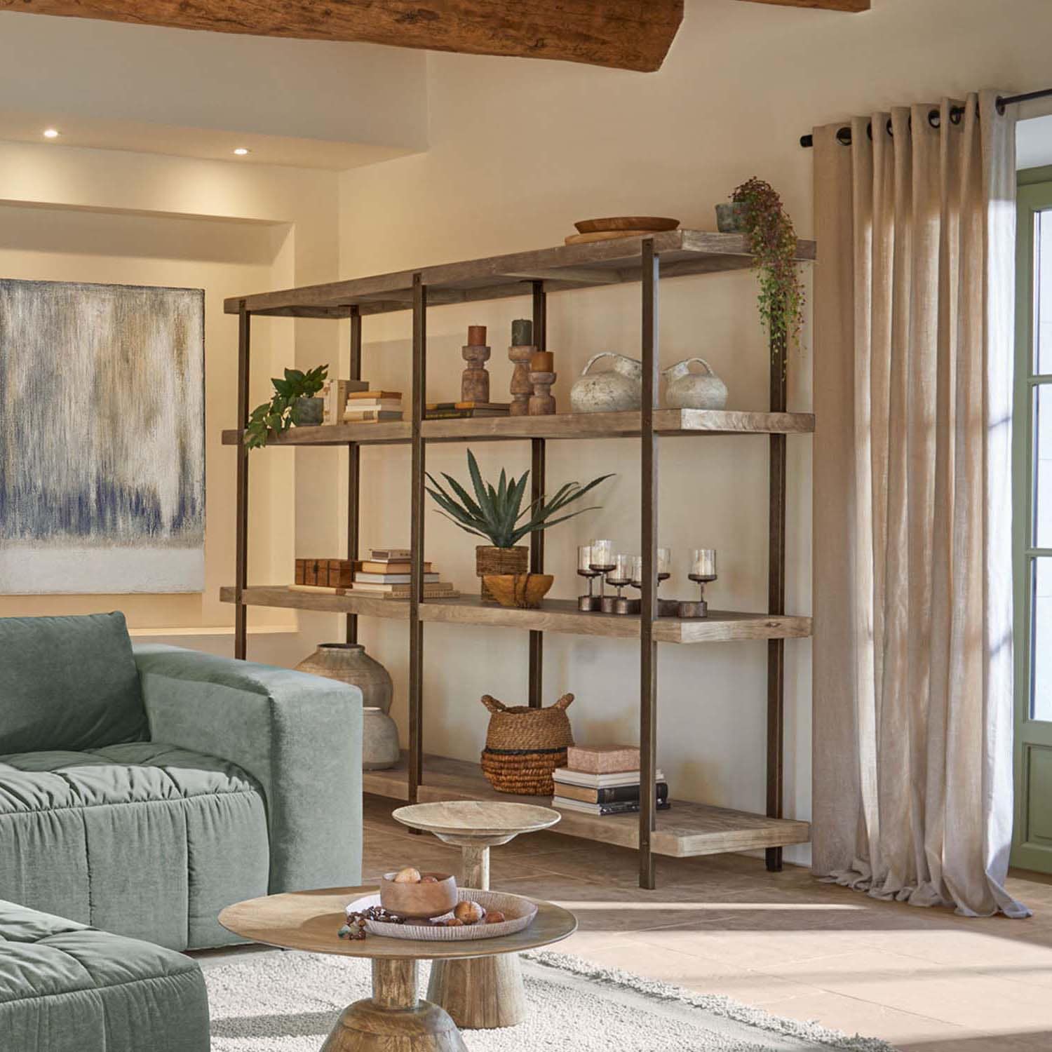 Gran estantería de madera con marco metálico en color natural, decoraciones y plantas en sala de estar
