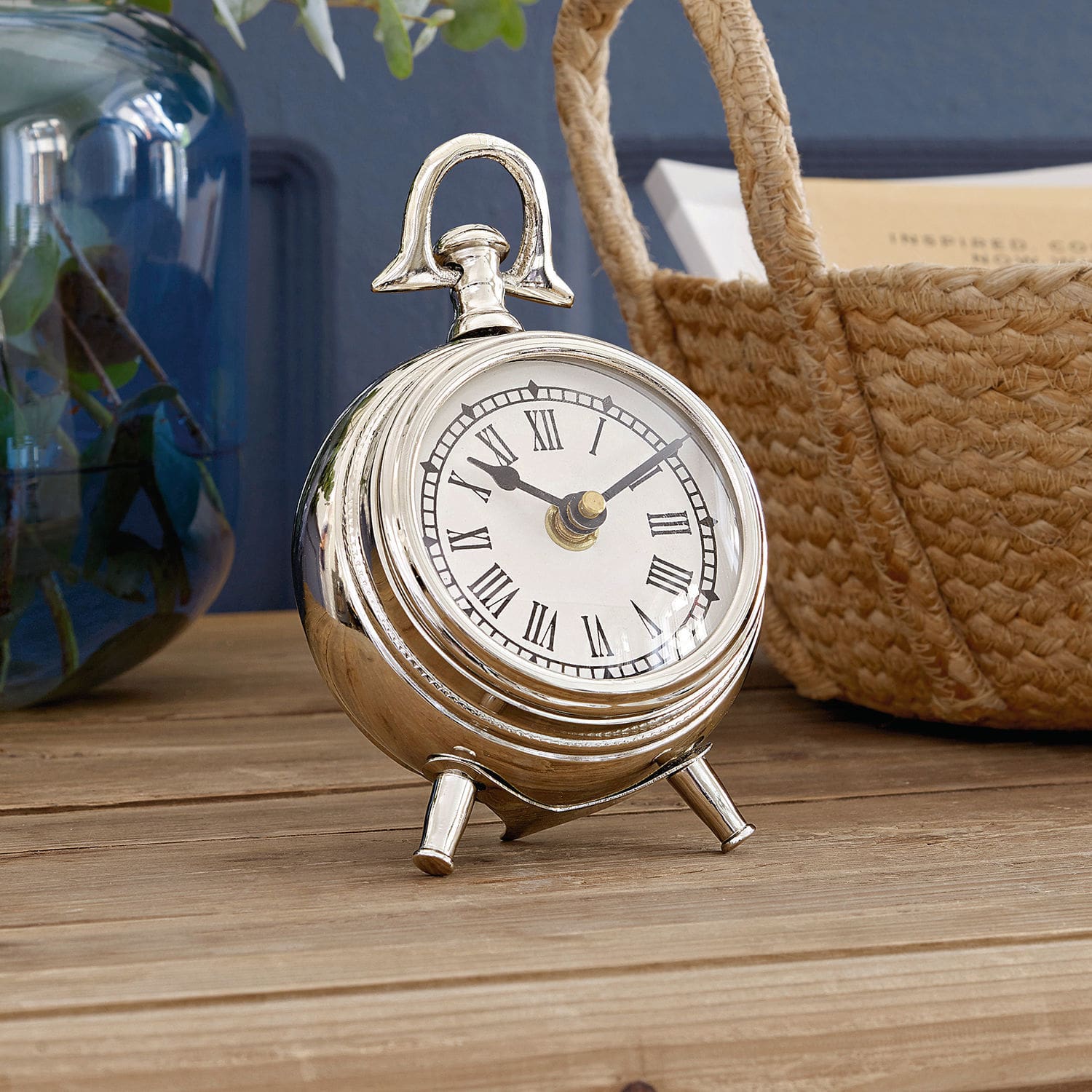 Reloj Coraten Reloj de mesa metálico plateado con números romanos sobre superficie de madera, decoración interior
