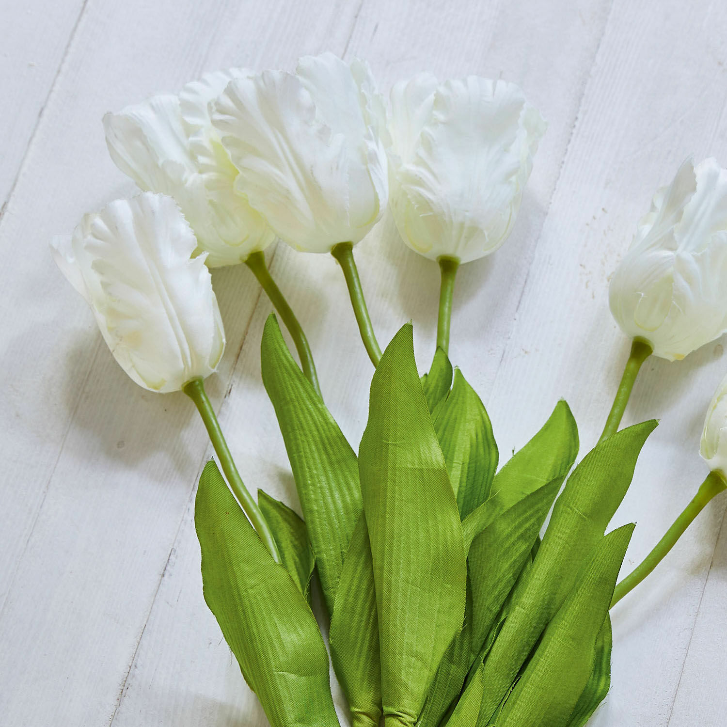 Ramo de tulipanes blancos con hojas verdes sobre fondo claro, decoración primaveral