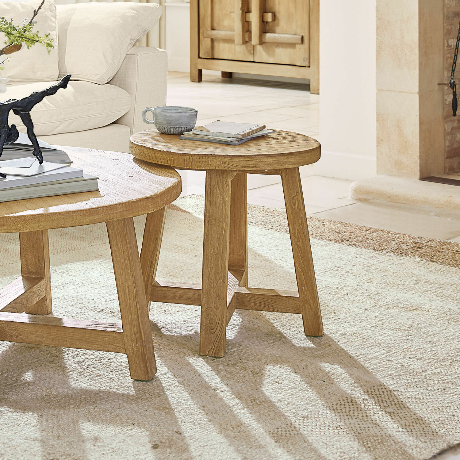 Mesa auxiliar Gorivel Mesa de centro redonda de madera natural sobre alfombra clara en sala con sofá beige