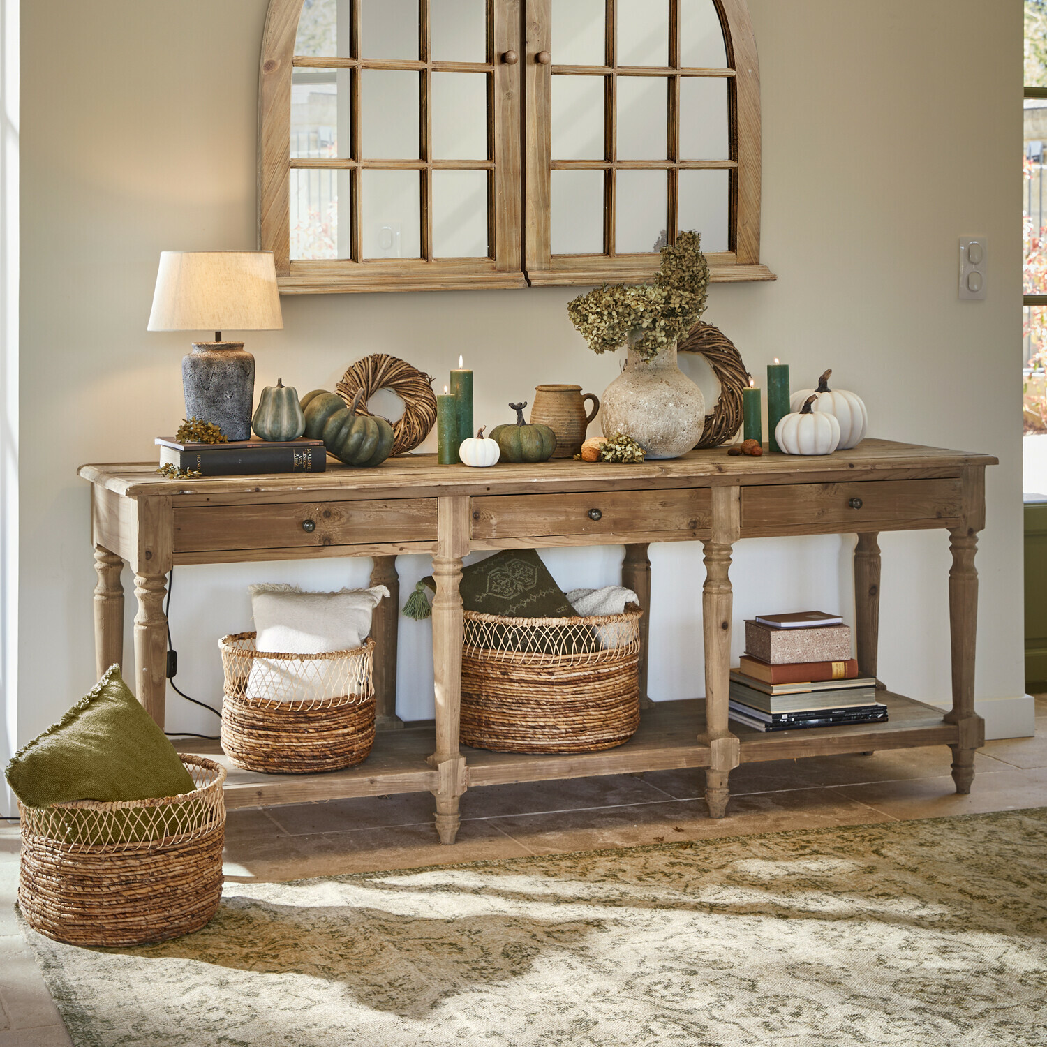 Consola Misérieux Consola de madera con decoración otoñal, lámpara y cestas de mimbre en un interior acogedor