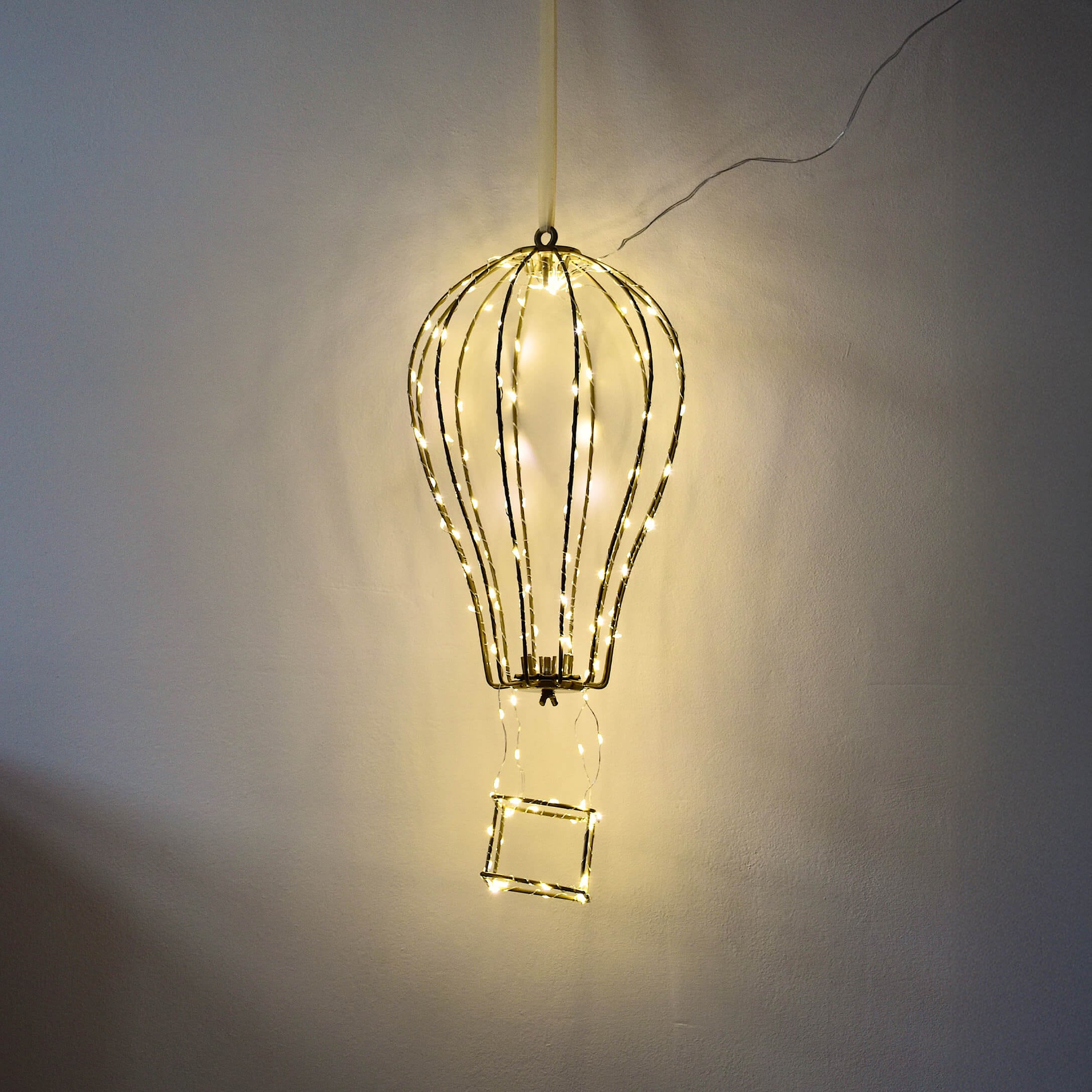 Lámpara decorativa en forma de globo aerostático con estructura metálica y luces LED cálidas en la pared