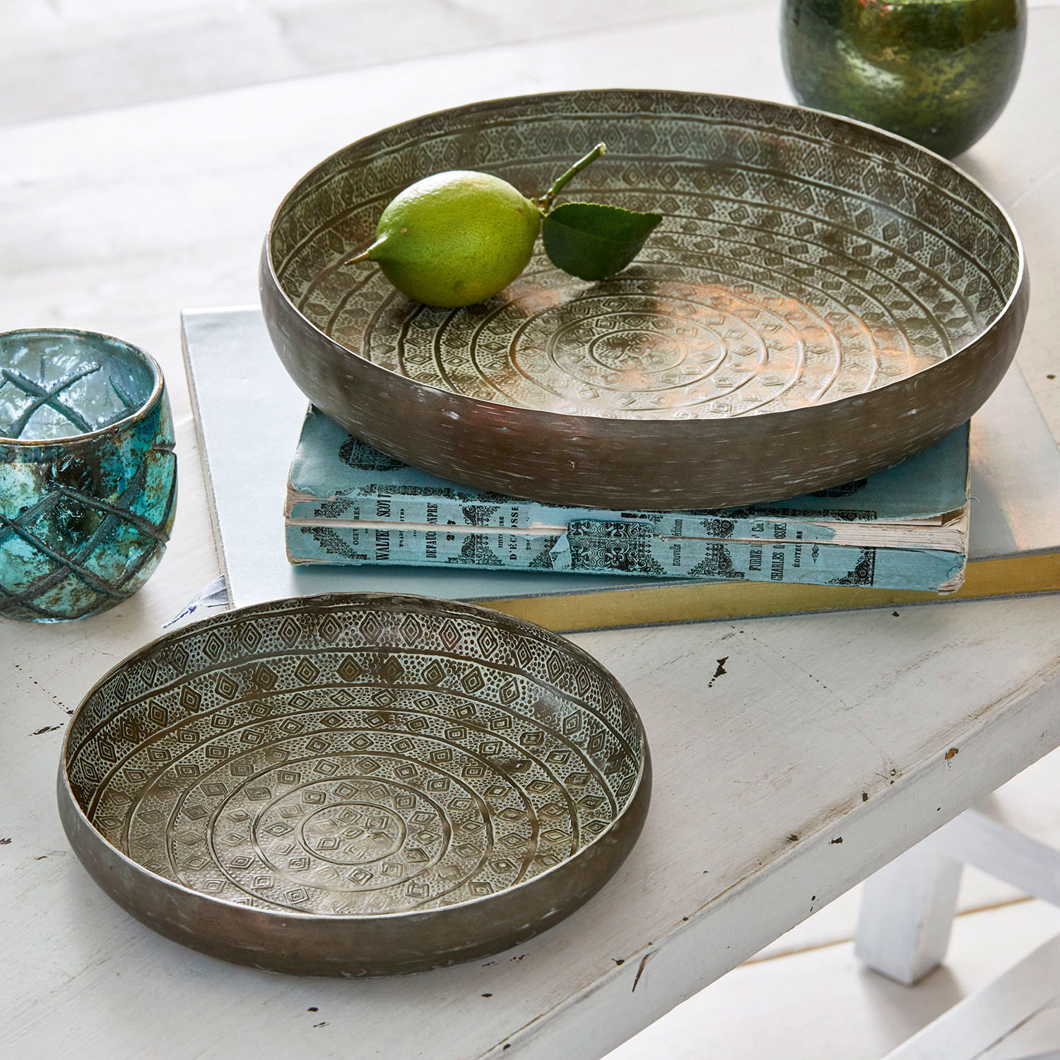 Set de 2 bandejas Birse Conjunto de dos cuencos metálicos con diseño decorativo en color plata envejecida sobre mesa blanca