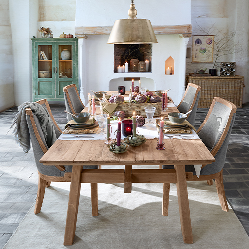 Mesa de comedor rústica de madera con sillas tapizadas grises y decoración festiva elegante