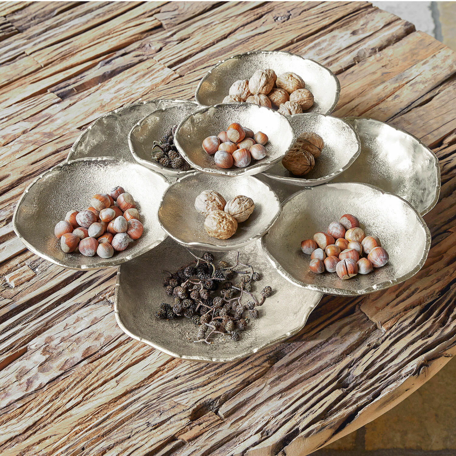 Tazón Gibril Fuente decorativa de metal plateado con nueces y frutos secos sobre mesa de madera rústica