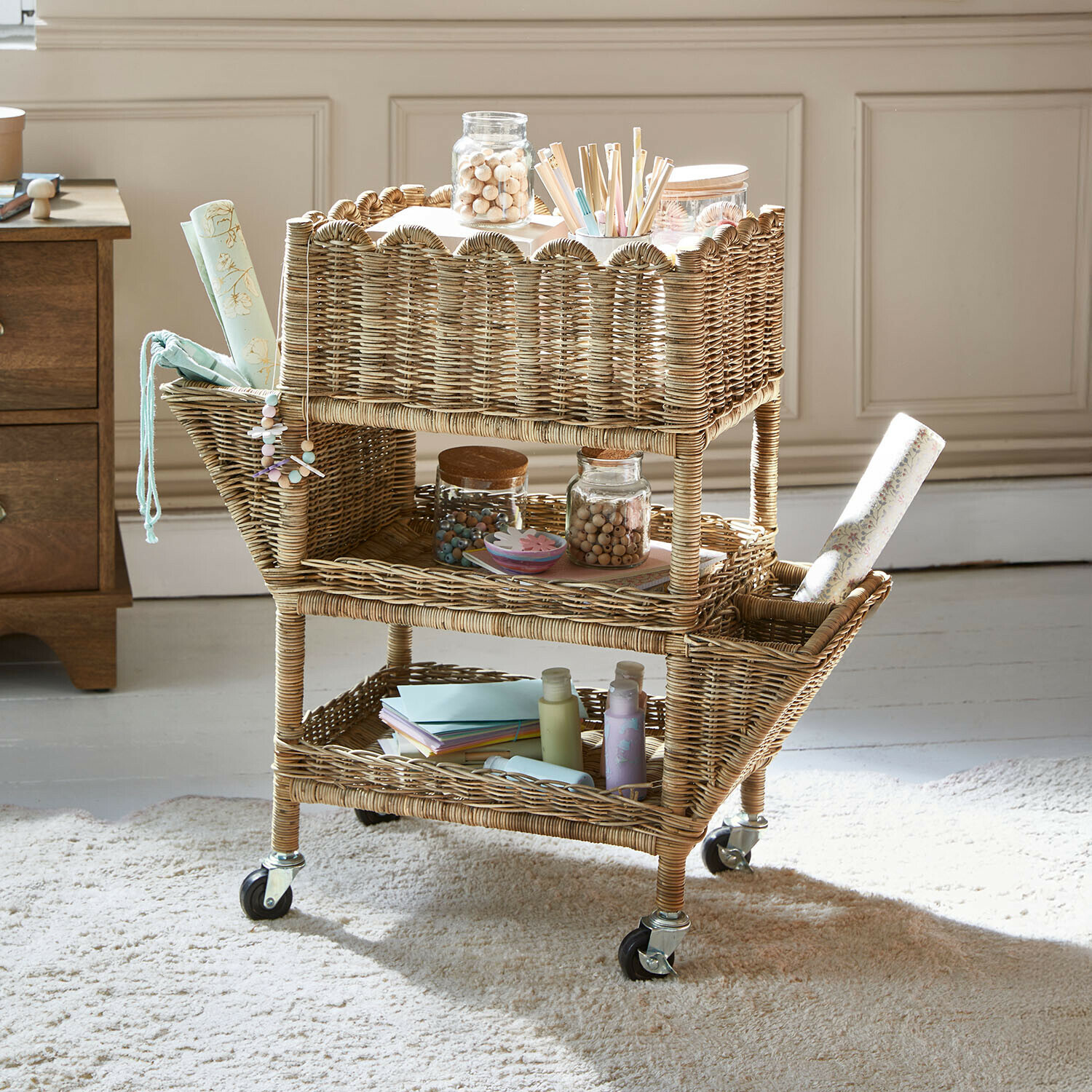 Carrito de ratán natural con ruedas, tres estantes y compartimentos laterales para almacenar artículos de oficina
