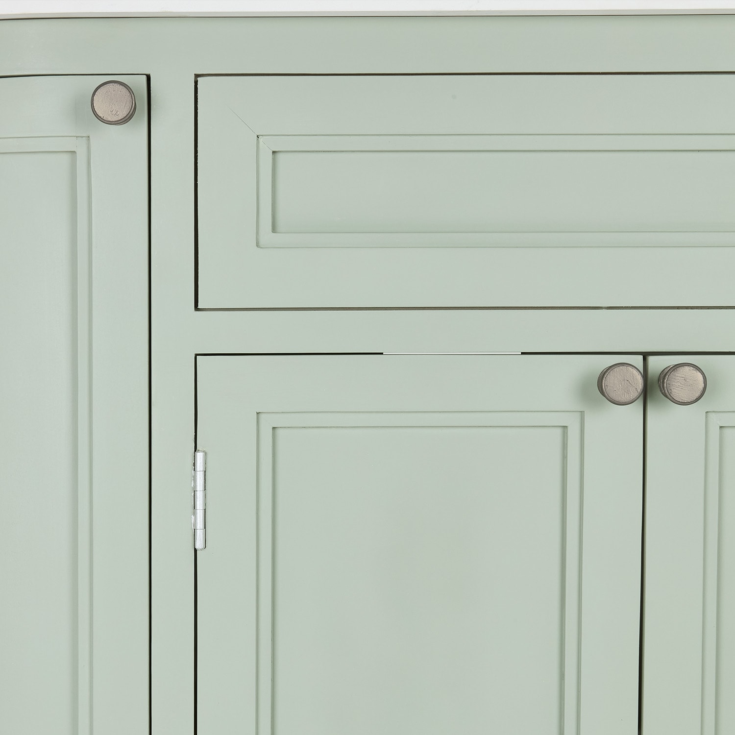 Frente de armario verde pastel con pomos de madera y paneles clásicos para almacenamiento