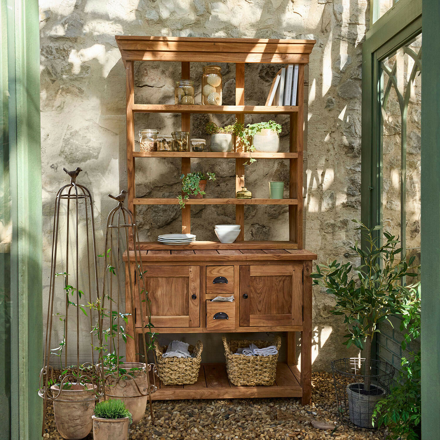 Alacena Ellamie Aparador de madera natural con estantes y cajones, decorado con plantas y vajilla en ambiente luminoso