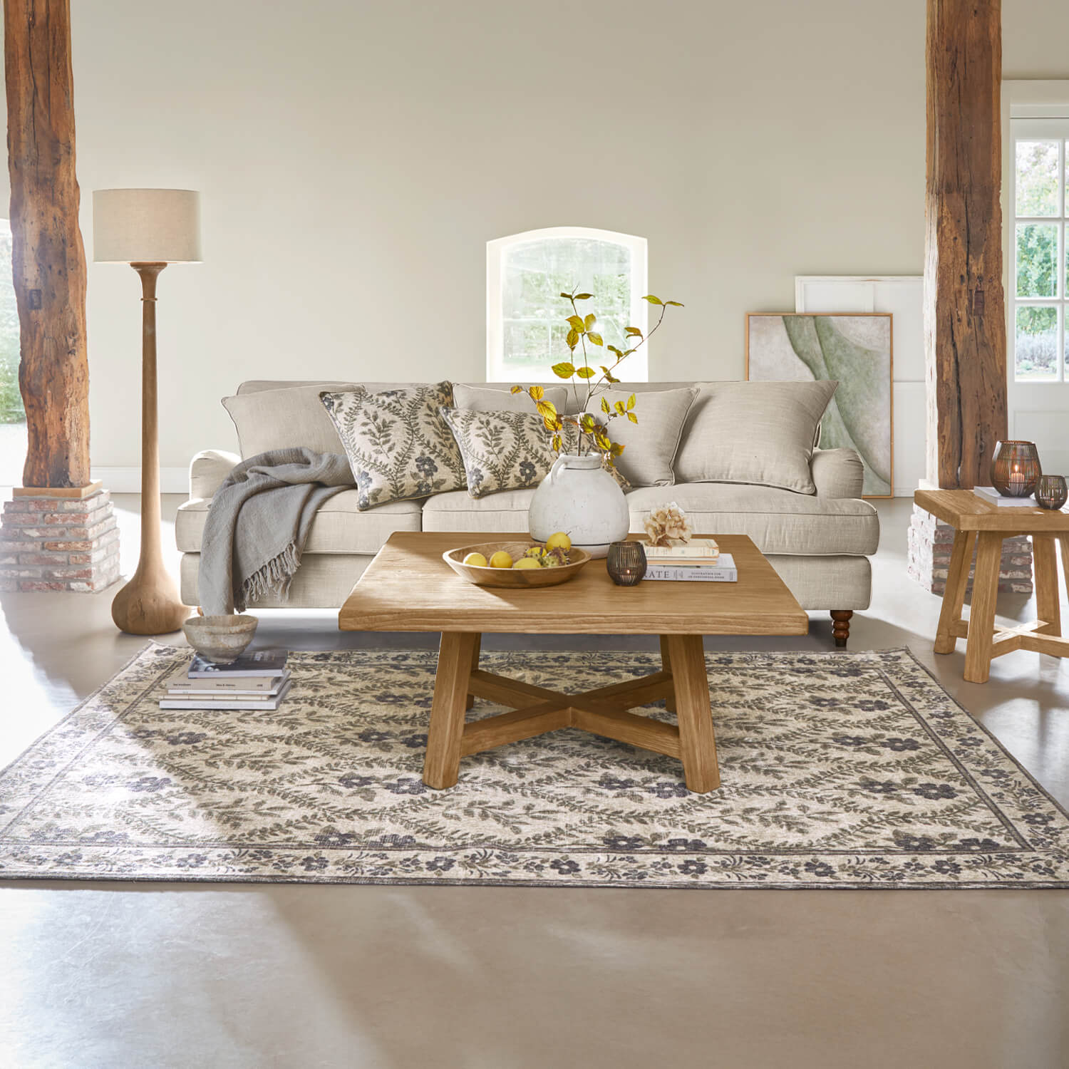 Sala acogedora con sofá beige, mesa de centro de madera y alfombra con diseño floral
