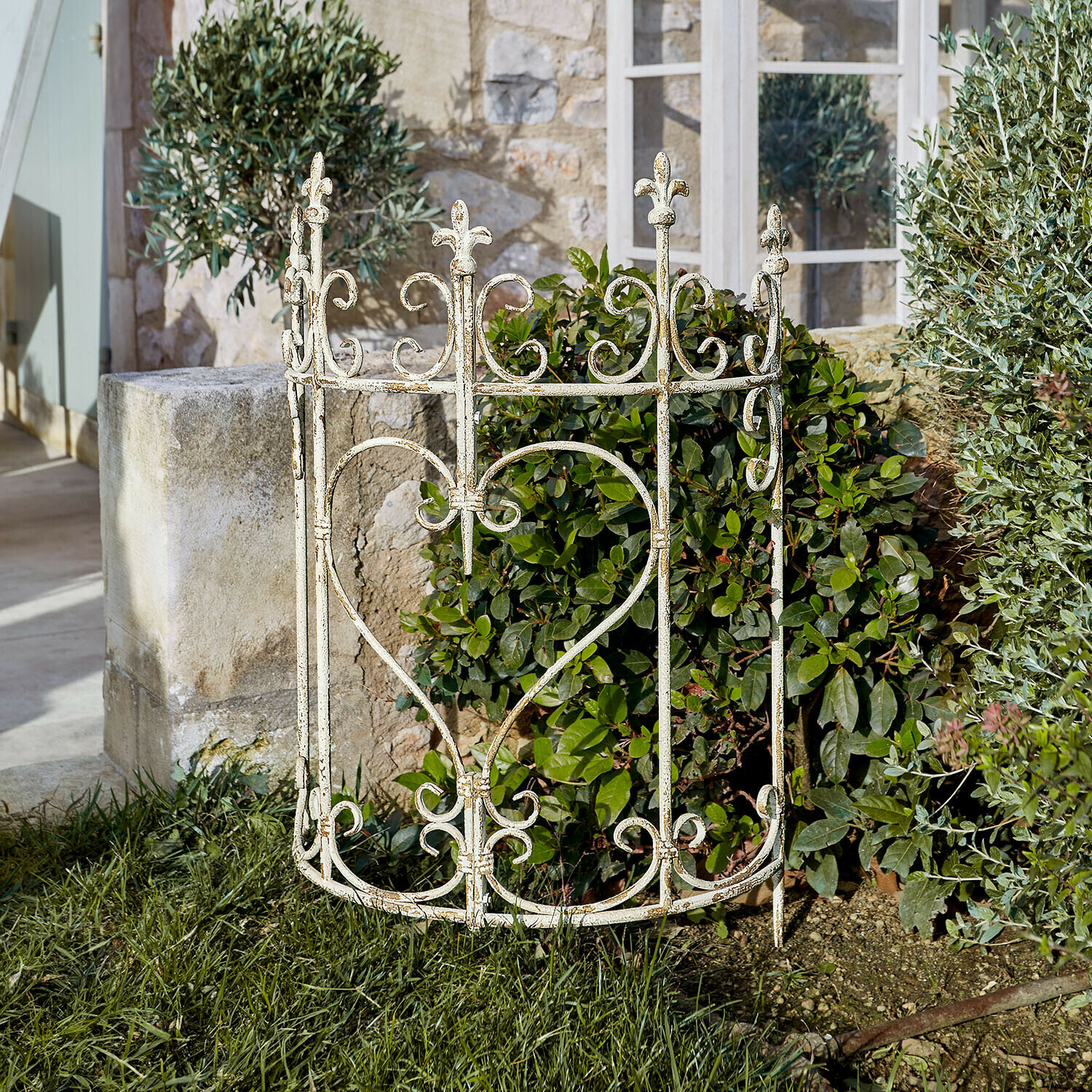 Enrejado para plantas Bramwell Valla de jardín de metal blanco con diseño de corazón y adornos florales sobre césped verde