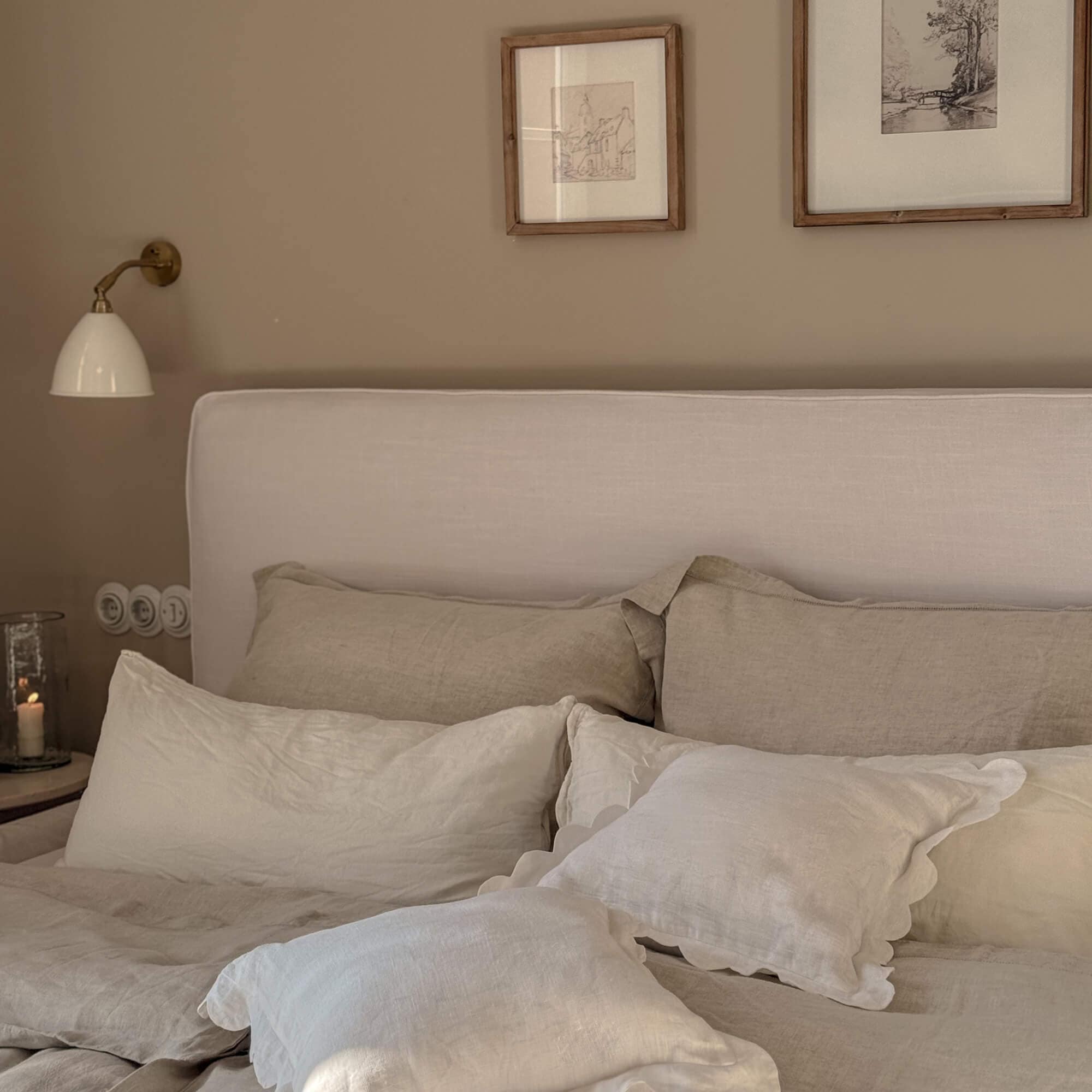 Dormitorio acogedor con ropa de cama beige de lino y cabecero tapizado claro