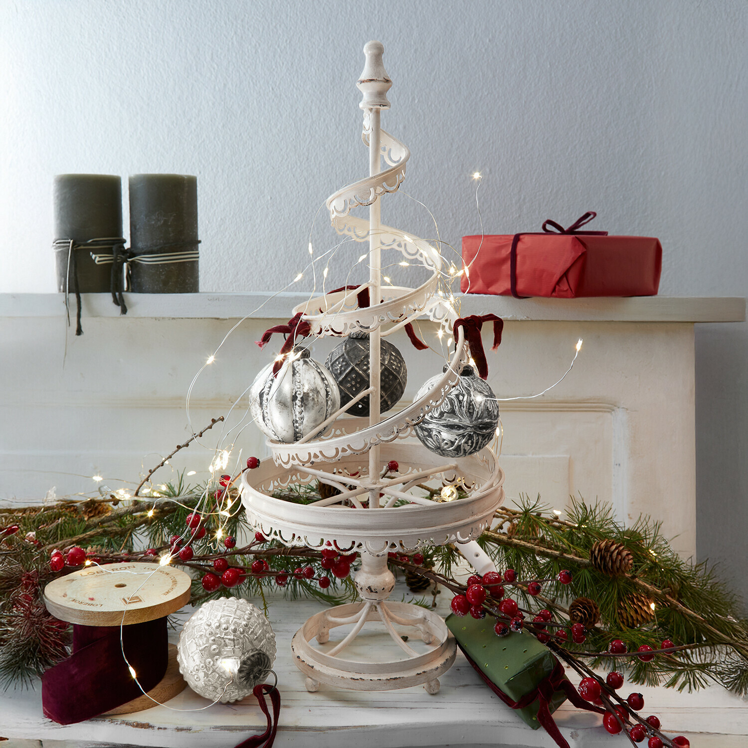Árbol decorativo Gerzat Decoración navideña de metal blanco con bolas colgantes y luces LED, regalos rojos y ramas verdes al fondo
