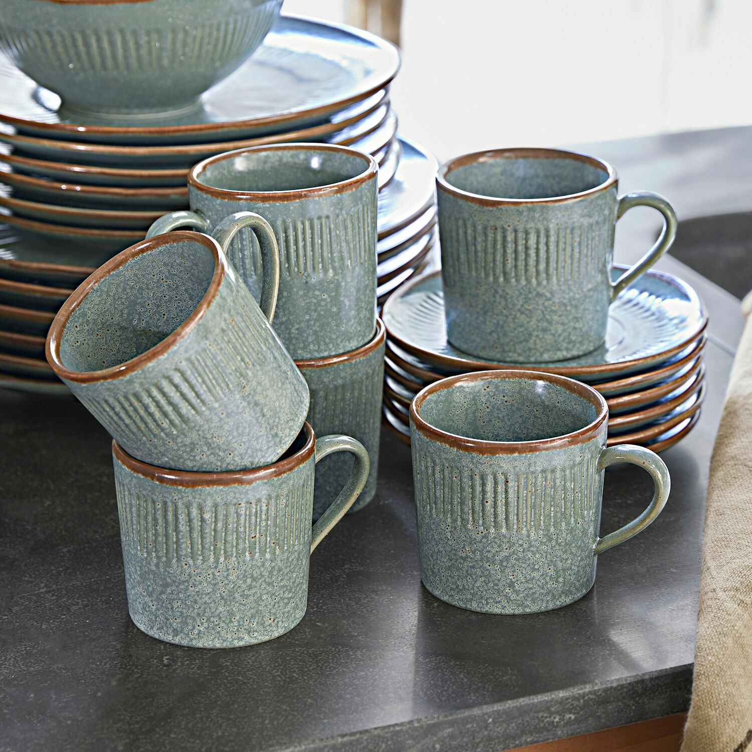 Set de 6 tazas con platillos Périers Juego de tazas y platos de cerámica verde con borde marrón sobre encimera de cocina