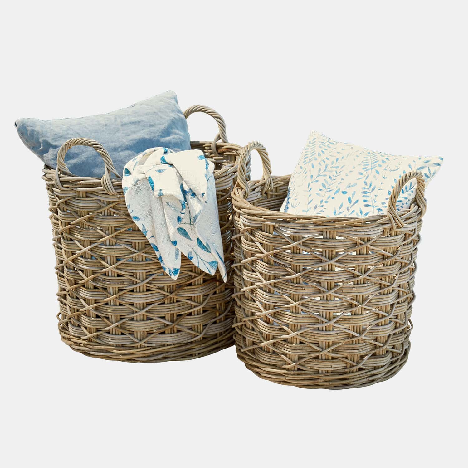 Dos cestas de mimbre natural con cojines y manta azul con estampado para almacenamiento decorativo
