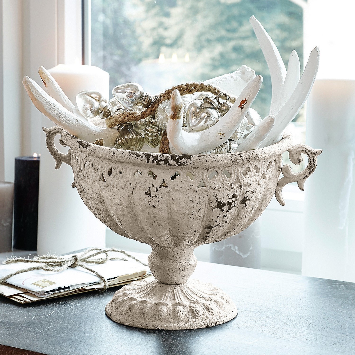 Cuenco decorativo de metal blanco estilo vintage con adornos y velas sobre mesa