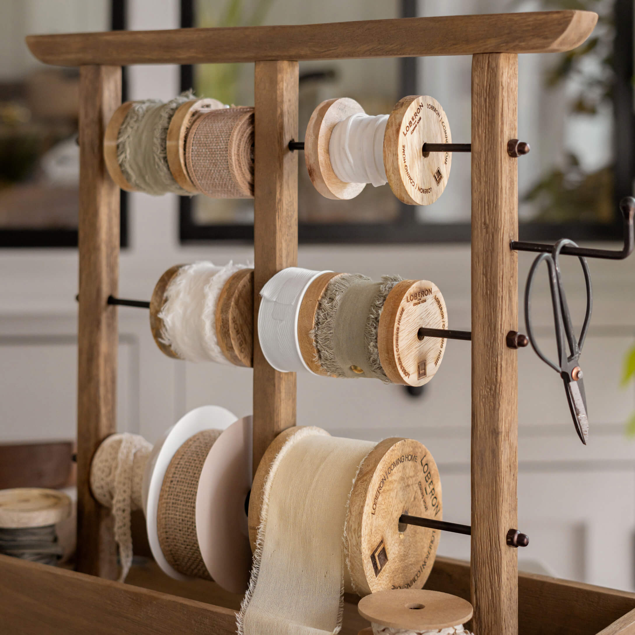 Soporte de madera con carretes de cintas naturales en tonos beige y blanco para manualidades