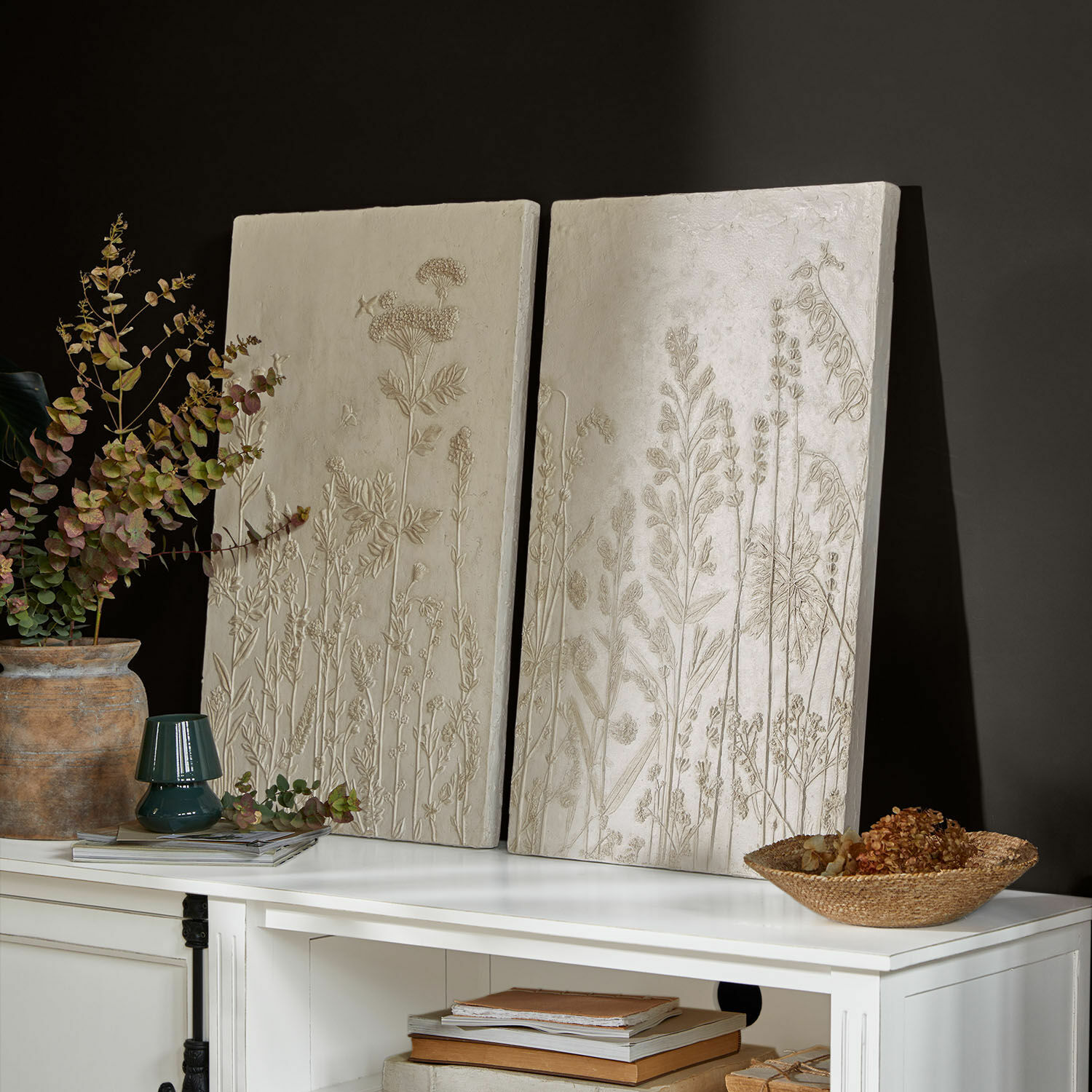 Set de 2 cuadros Almahara Paneles decorativos crema con relieve de plantas sobre mueble blanco en sala moderna